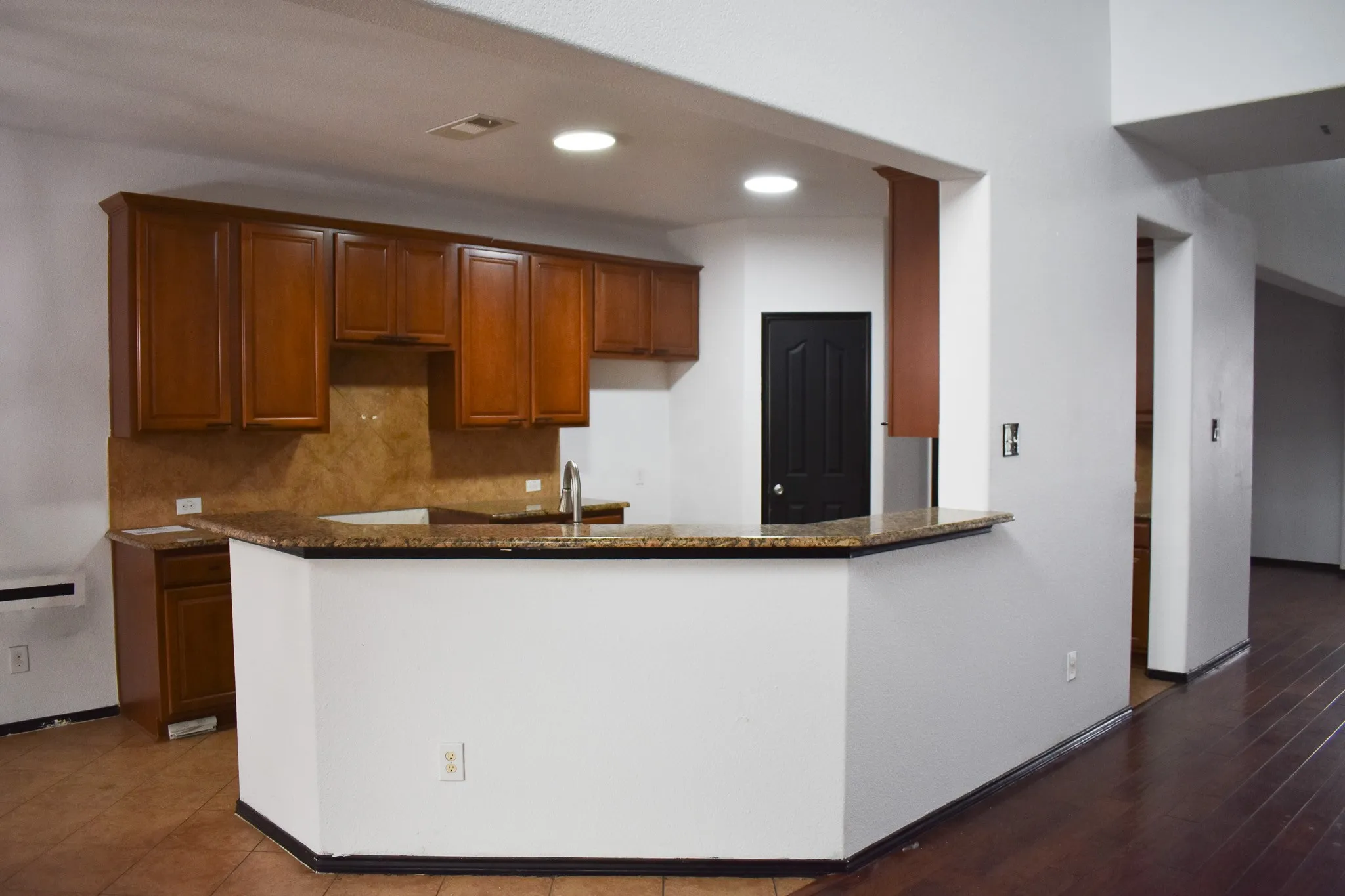 Kitchen featuring a breakfast bar, ample cabinetry, stone countertops, a stainless steel sink, and recessed lighting