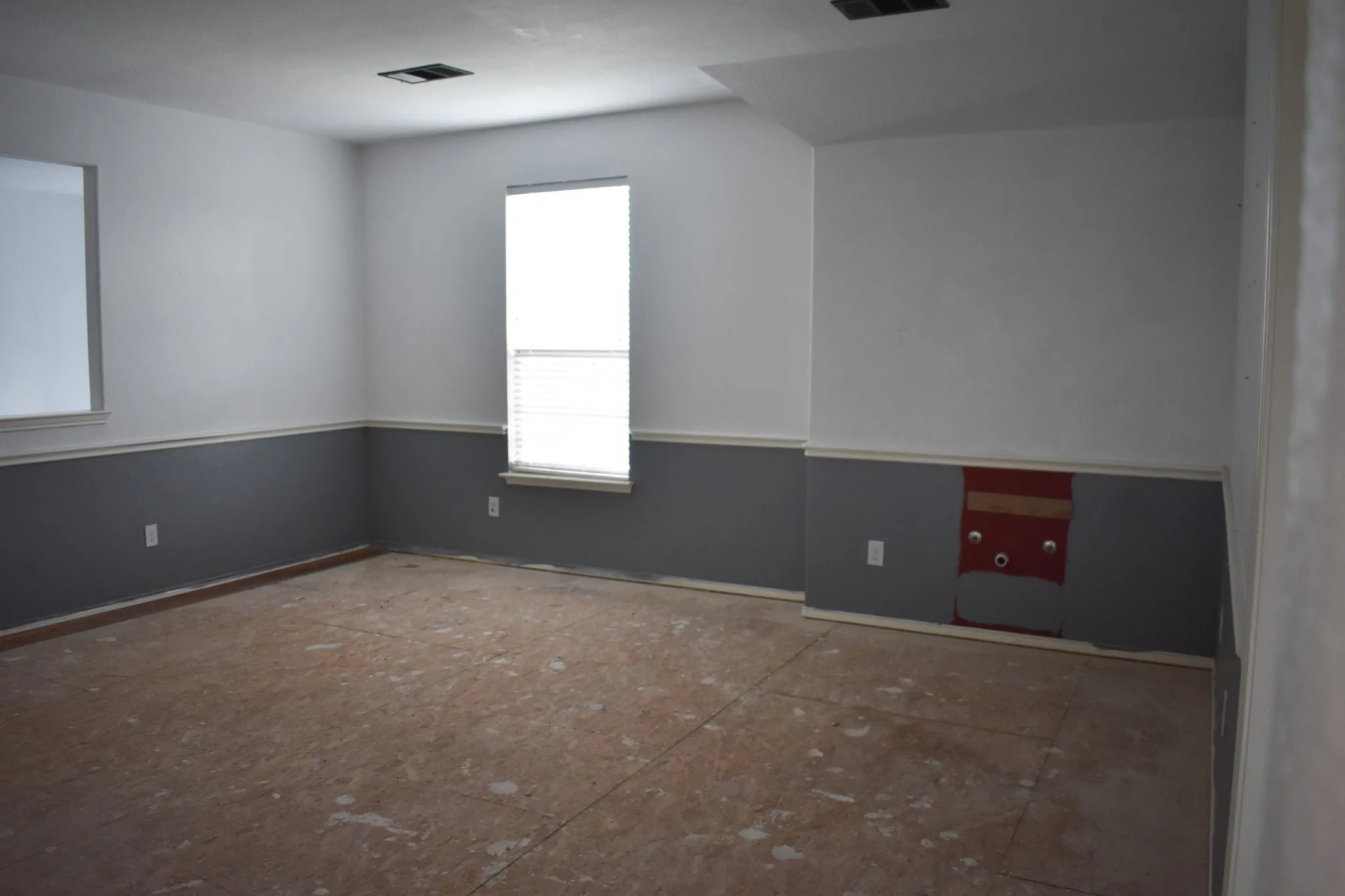 Interior room featuring a two-tone paint scheme with a neutral upper wall and a gray lower wall separated by white trim