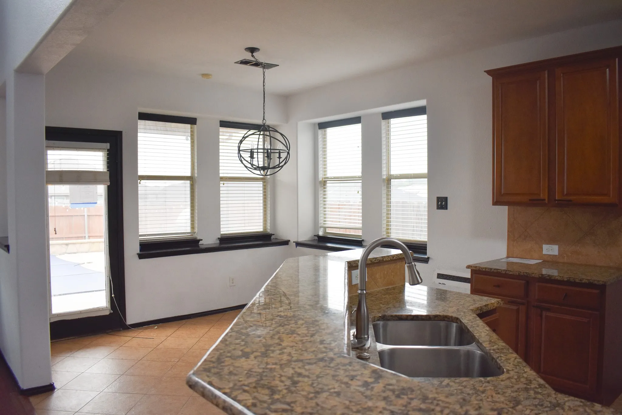 Kitchen island featuring a dual basin sink with a gooseneck faucet