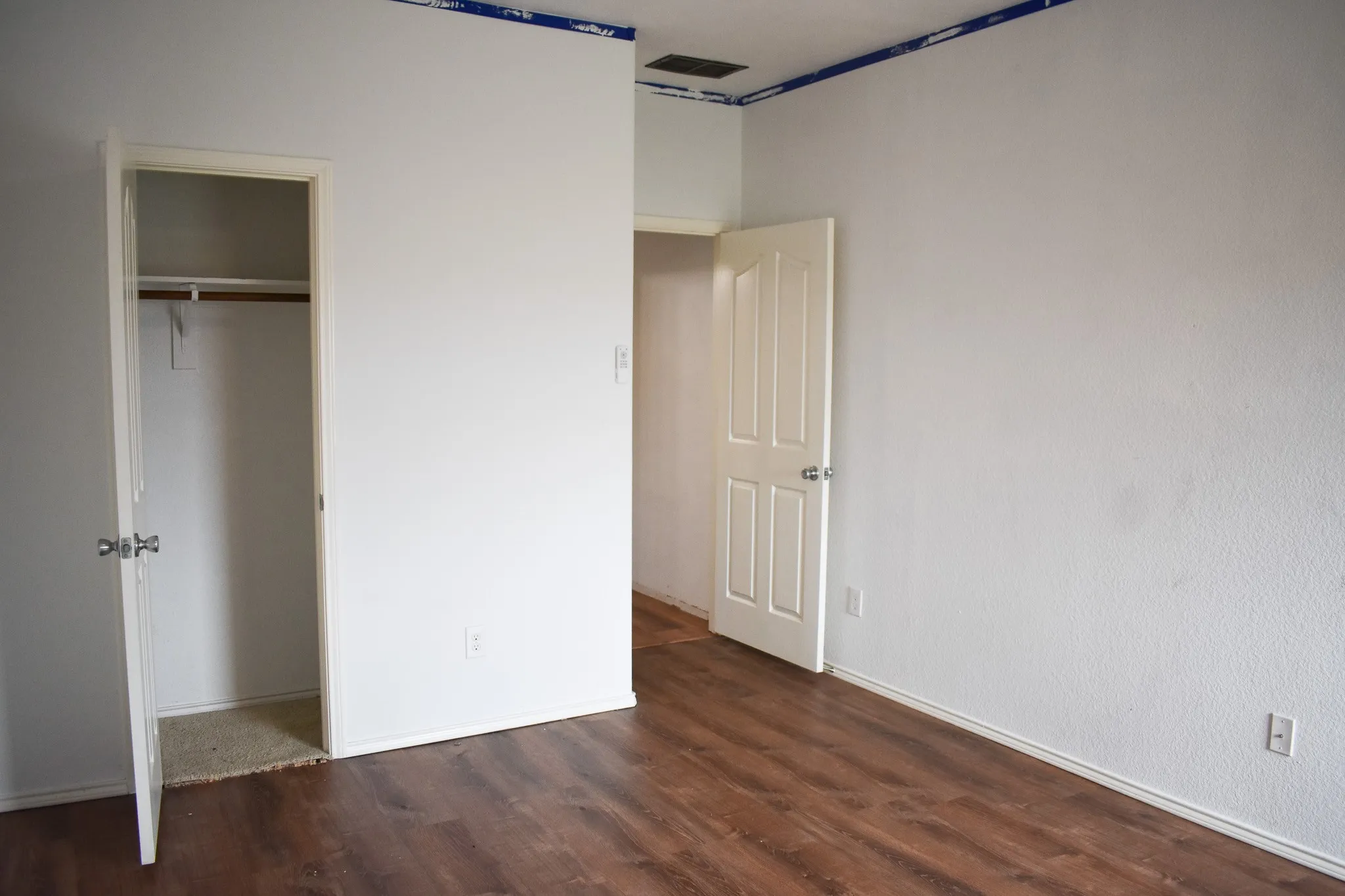 Room featuring wood-finish flooring and white painted walls