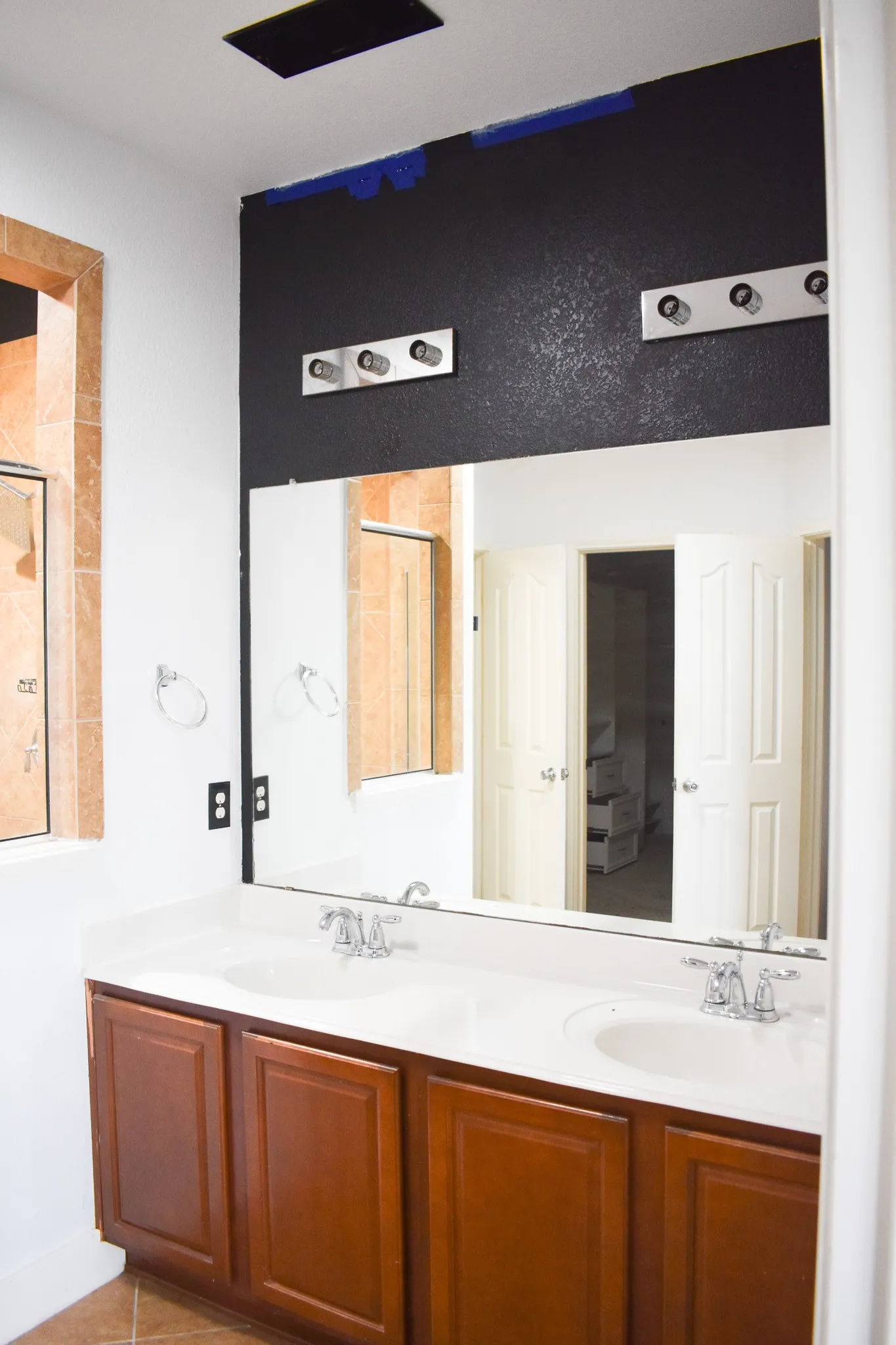Dual vanity with wood-finish cabinetry, integrated sinks, and chrome faucets