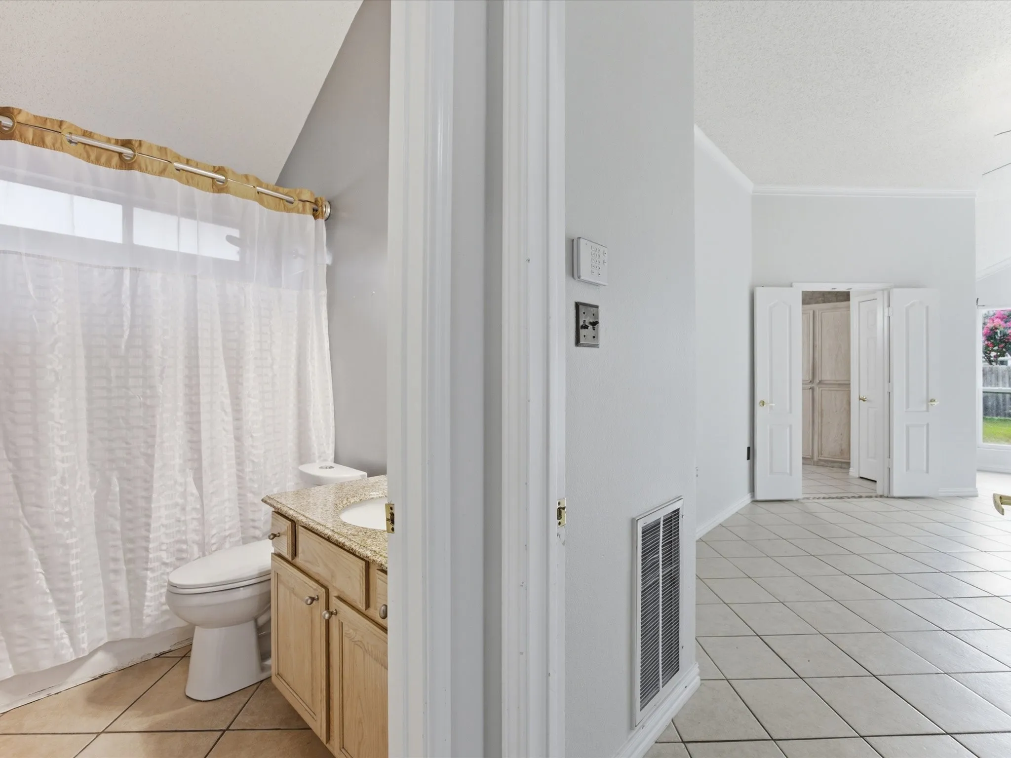 Bathroom featuring a single vanity with a stone countertop and light wood-finish cabinetry
