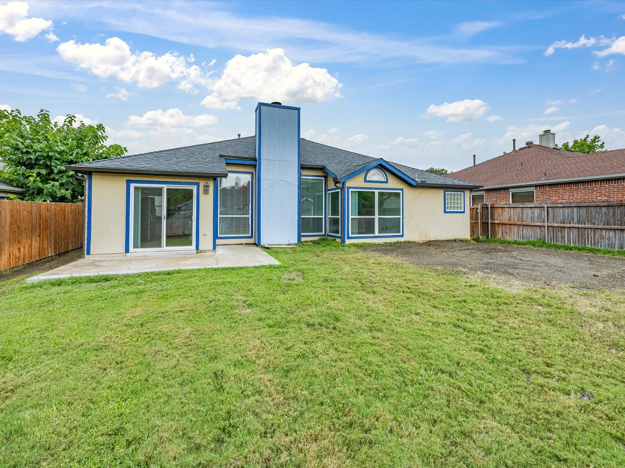 Backyard featuring a concrete patio and expansive lawn