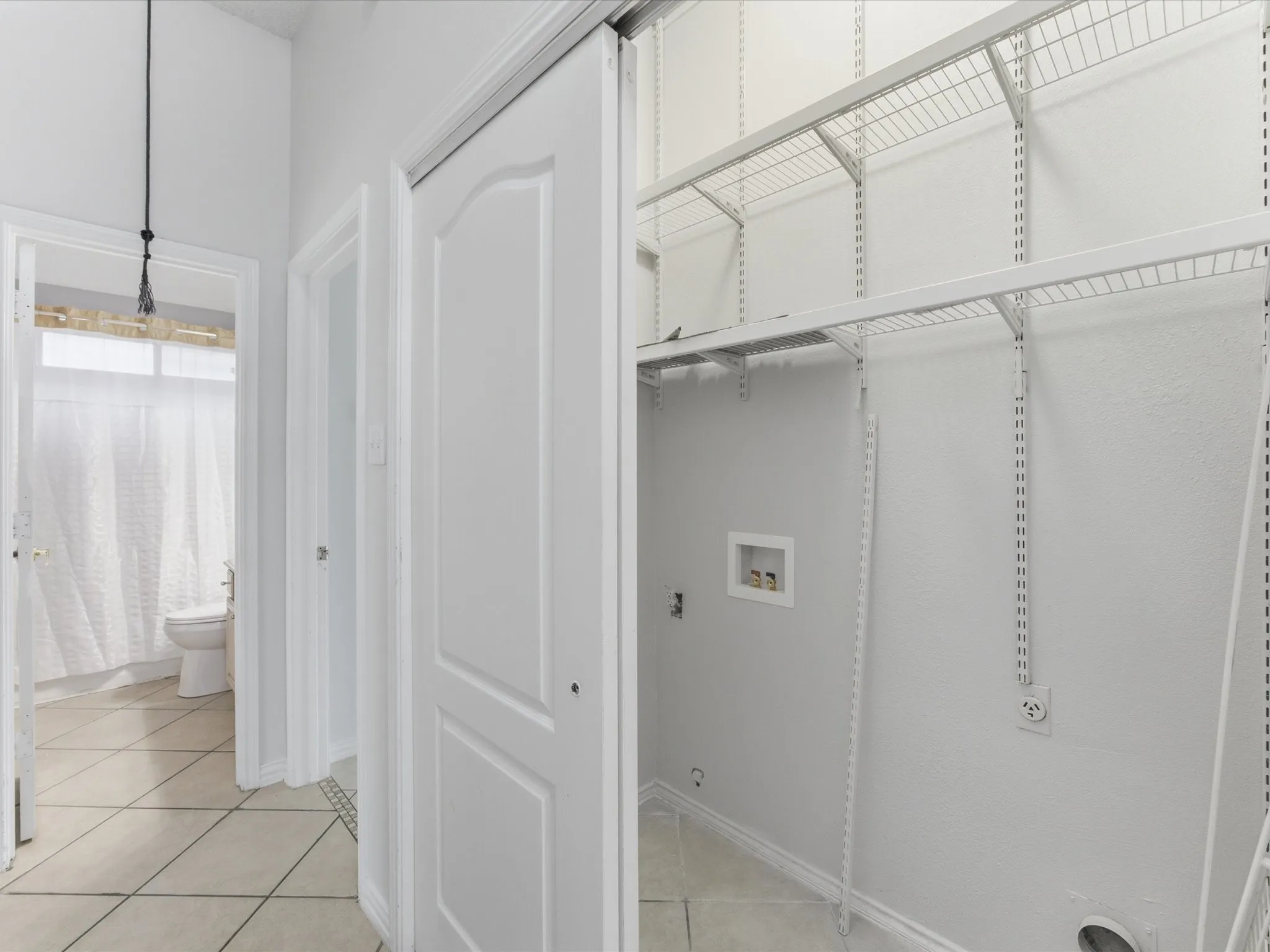 Dedicated laundry closet with wire shelving system and utility hookups