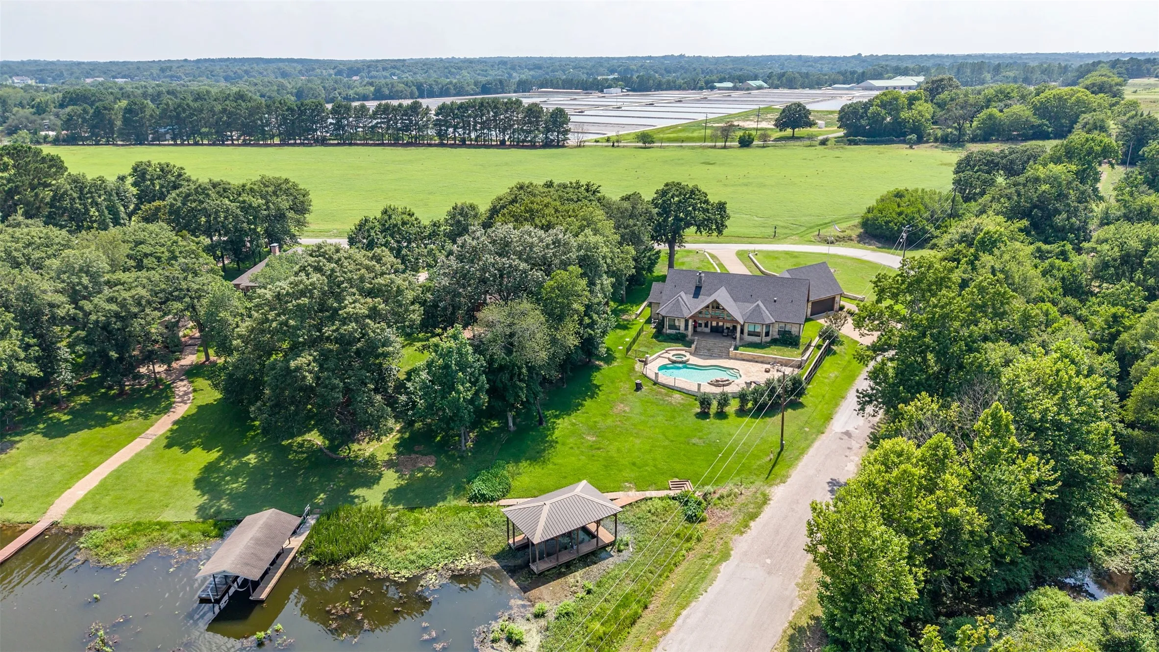 Expansive property featuring a residence with a covered front entrance and a paved driveway