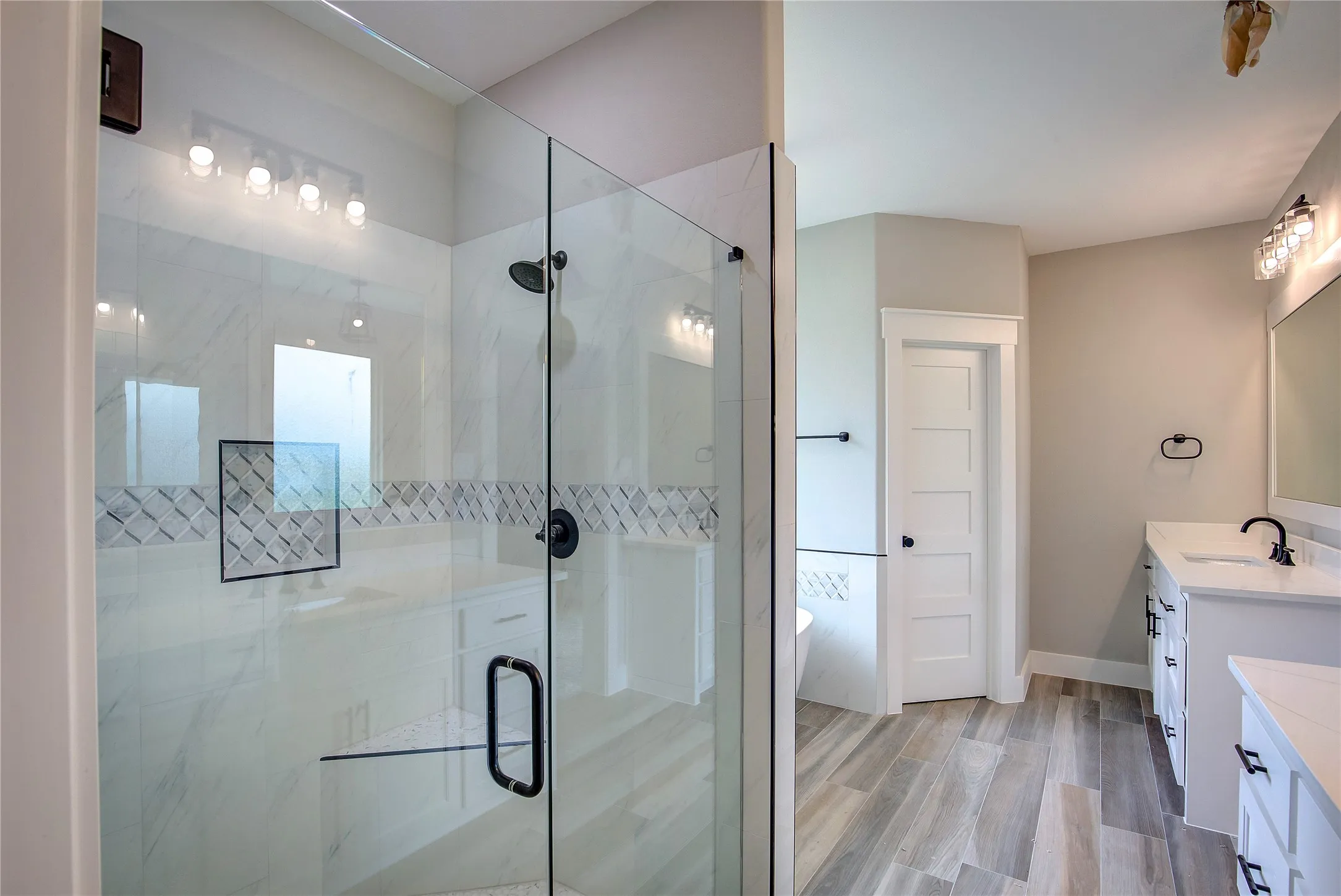 Bathroom with a shower with door, vanity, and hardwood / wood-style floors