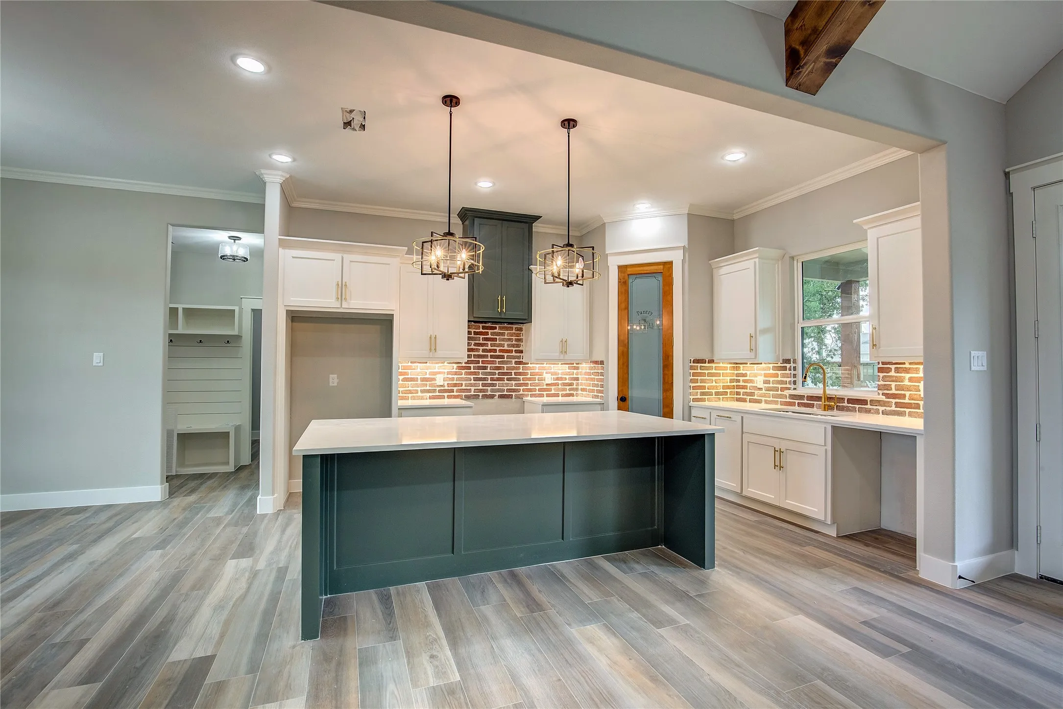 Kitchen with white cabinetry, a center island, and light wood-type flooring