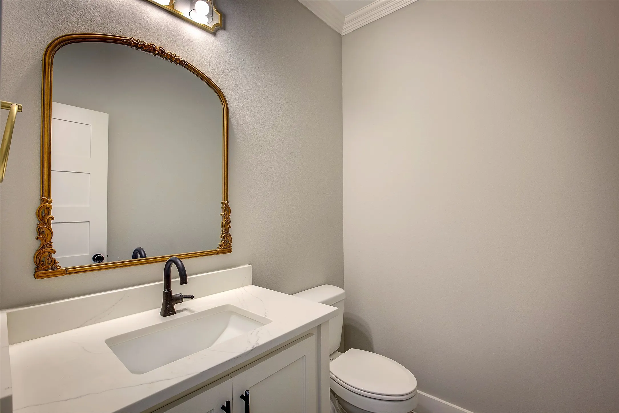 Bathroom with crown molding, toilet, and vanity
