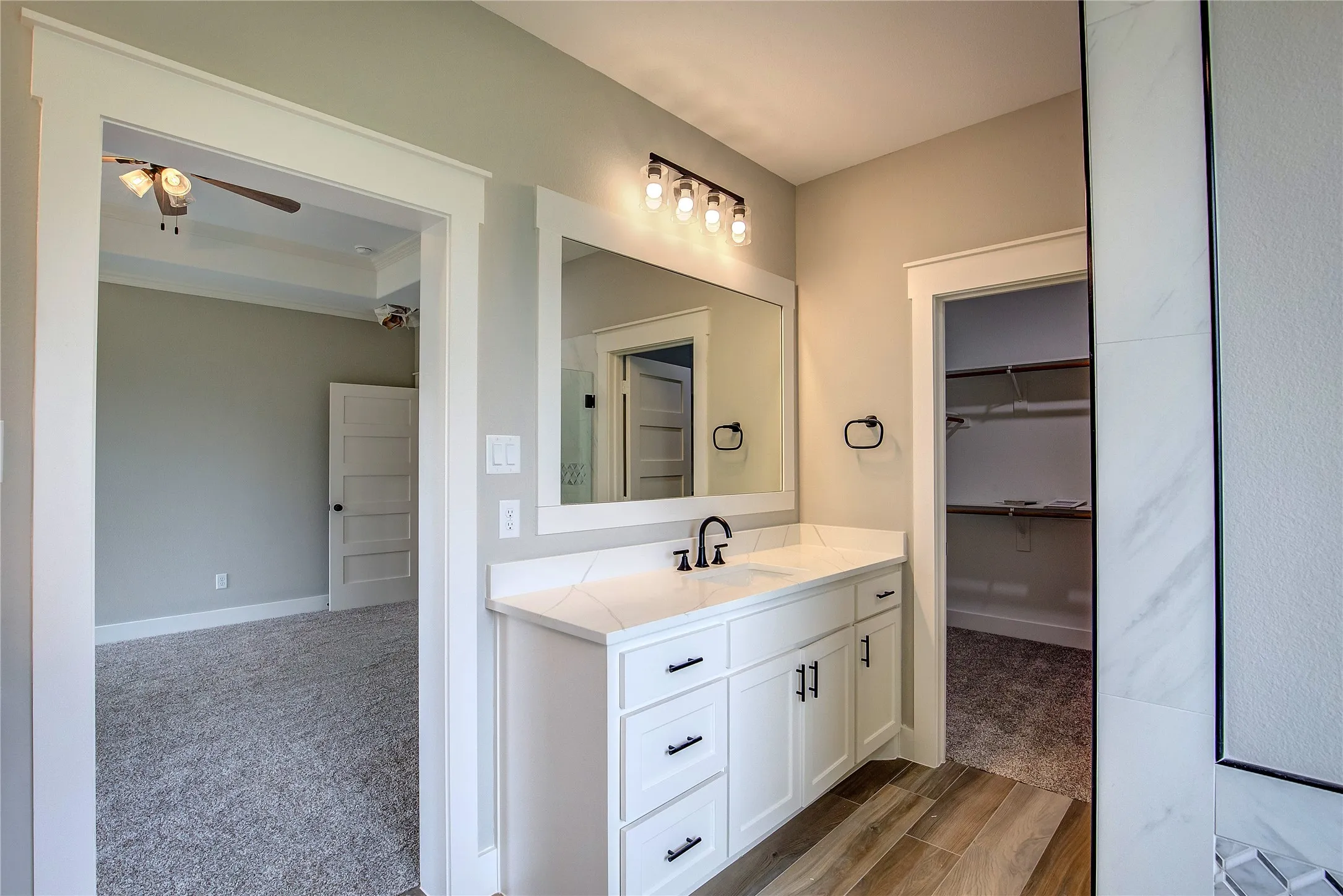 Bathroom with wood-type flooring, vanity, and ceiling fan