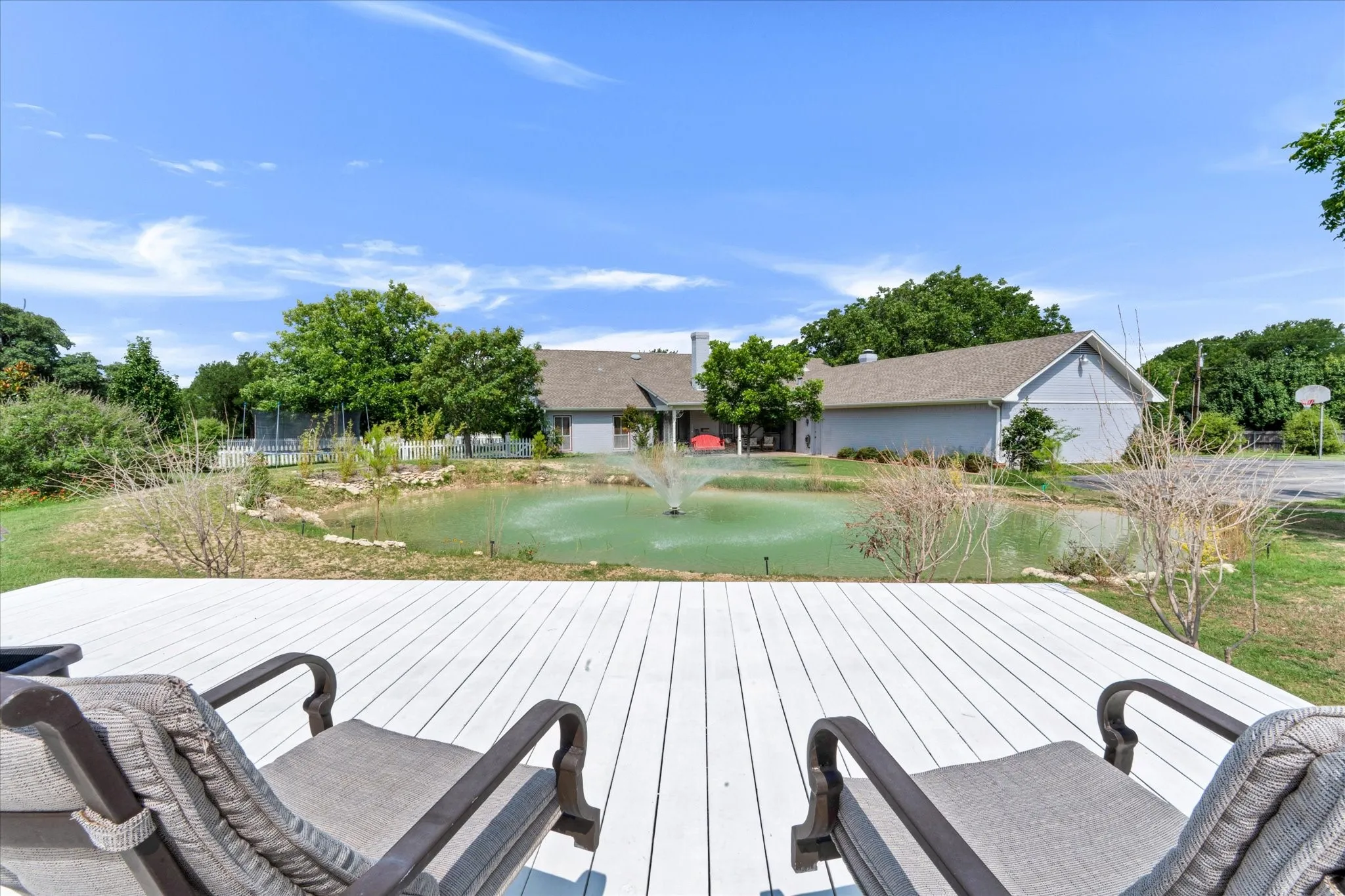 Spacious outdoor deck overlooking a private pond with a fountain feature