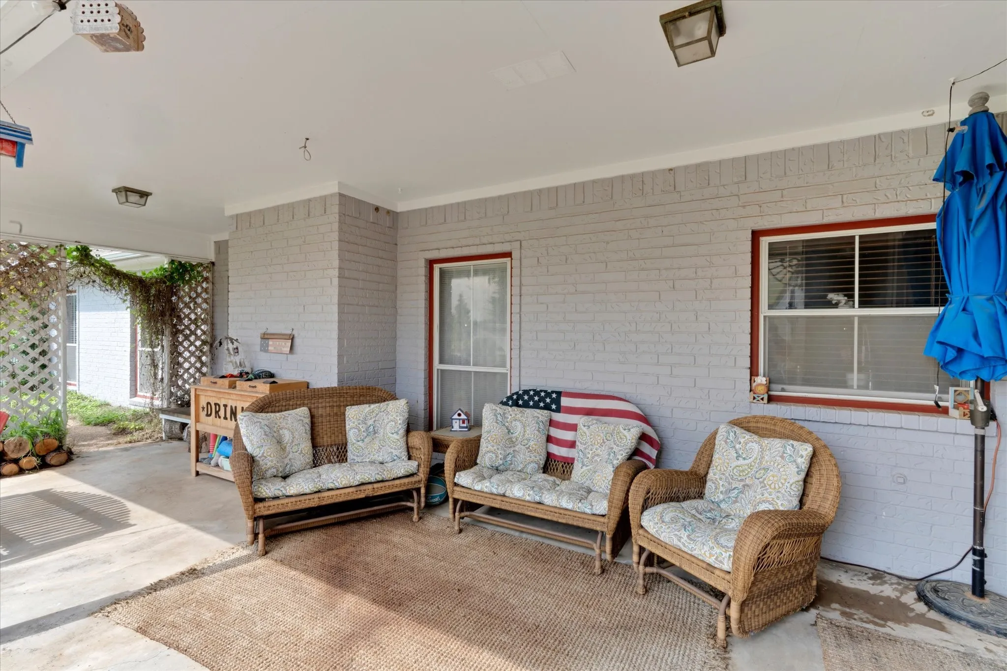 Covered patio with a concrete surface and painted brick exterior wall