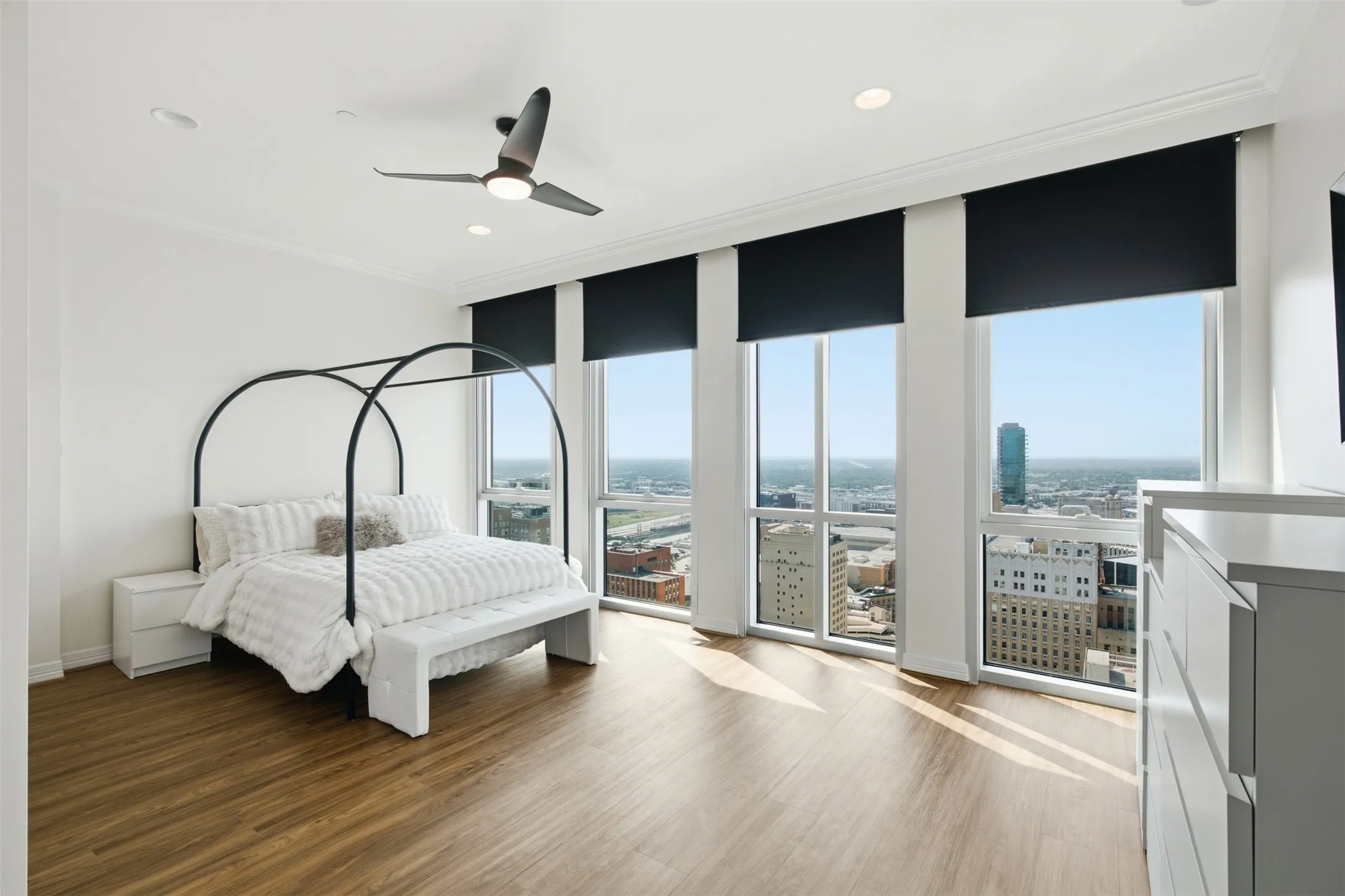 Wow! Expansive room views are perfect for those morning coffee in bed mornings!   featuring floor-to-ceiling windows with roller shades, wood-finish flooring, crown molding, and recessed lighting
