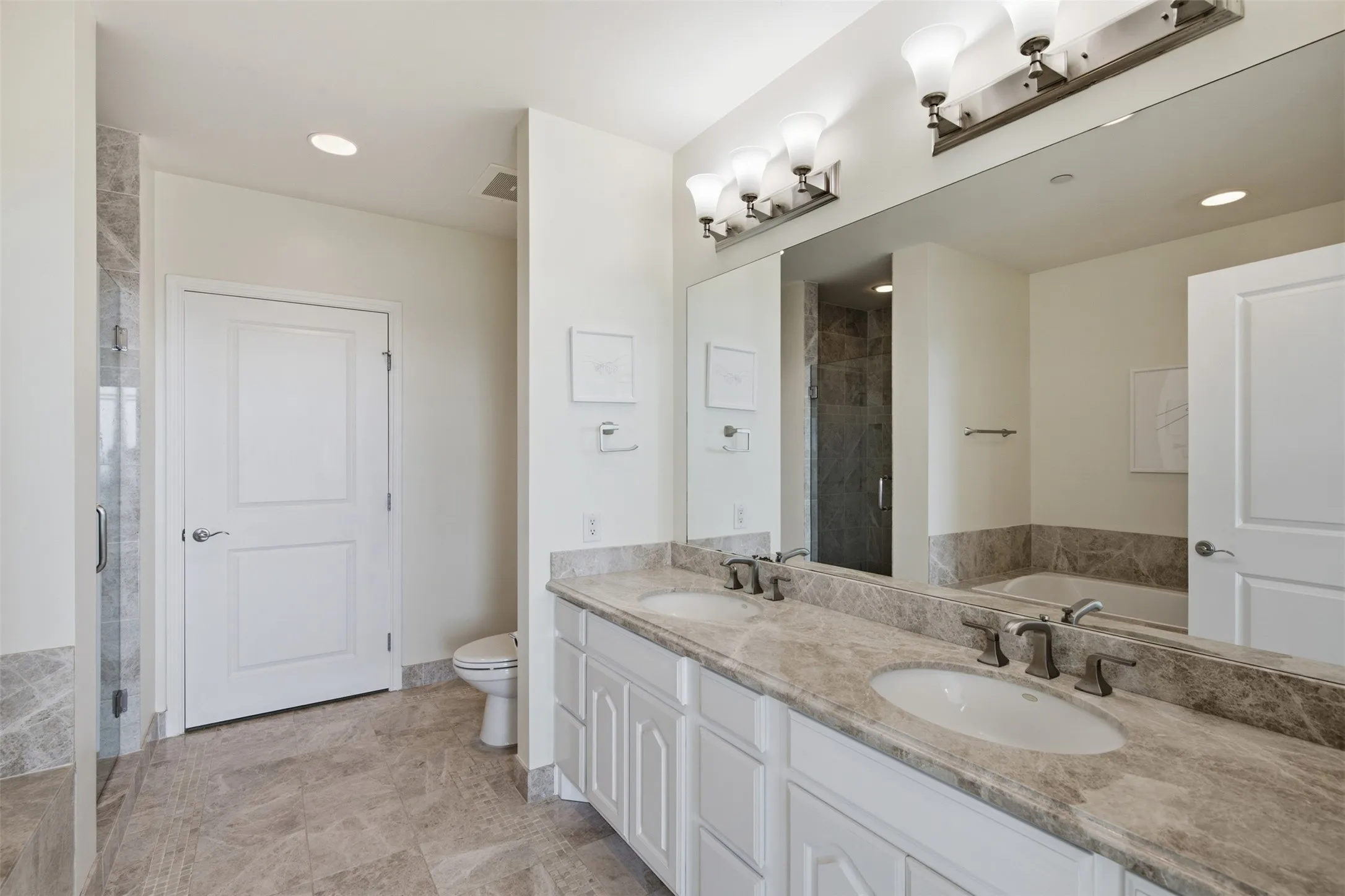 Primary Bath Double vanity with undermount sinks, brushed nickel fixtures, and a large unframed mirror with lots of counter space
