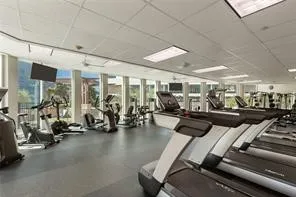 Tower Fitness center with expansive windows, integrated ceiling lighting, ceiling fans, and durable flooring