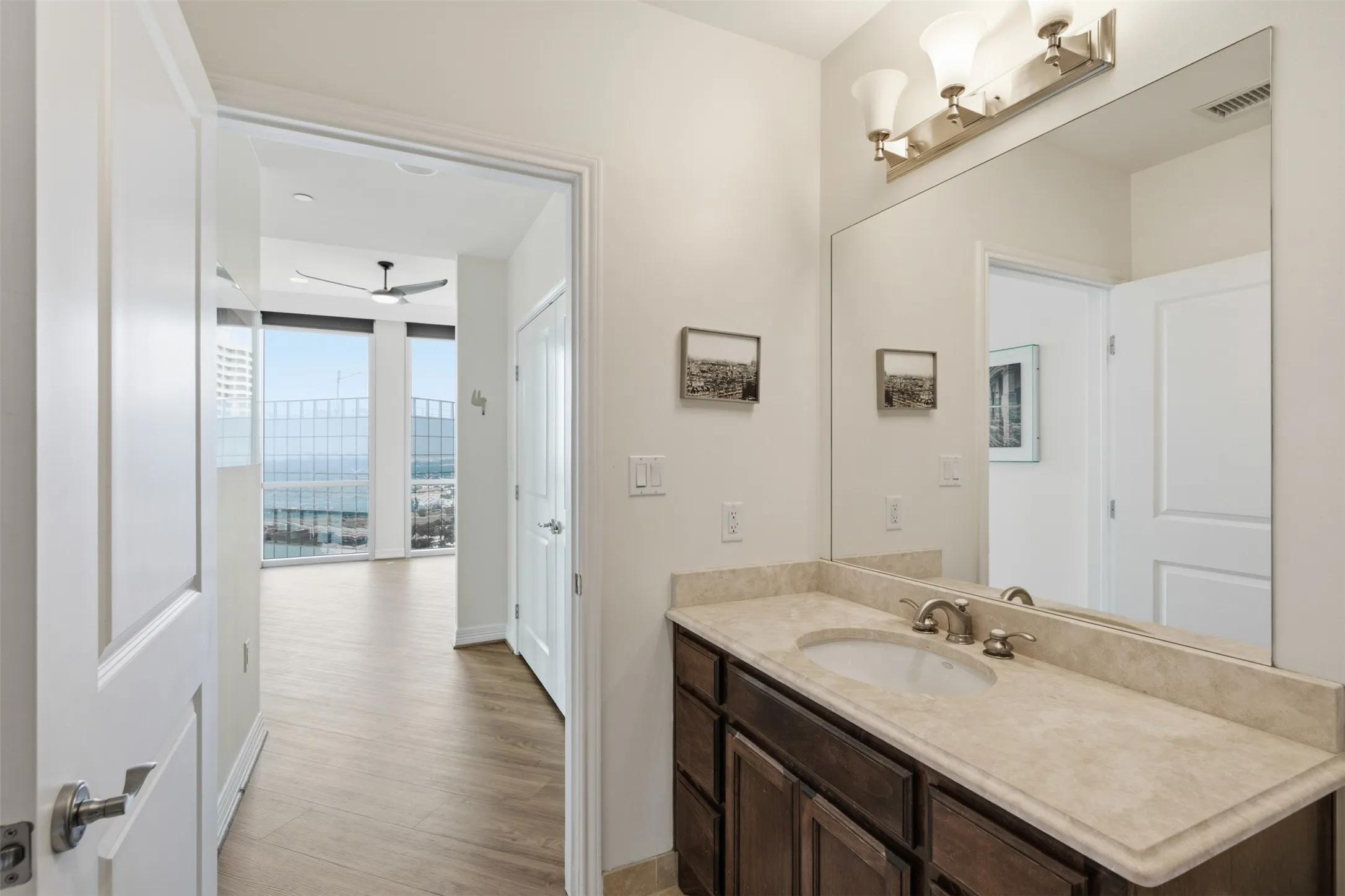 Secondary Full bathroom featuring a dark wood vanity with a light stone countertop, an undermount sink, and a large wall-mounted mirror