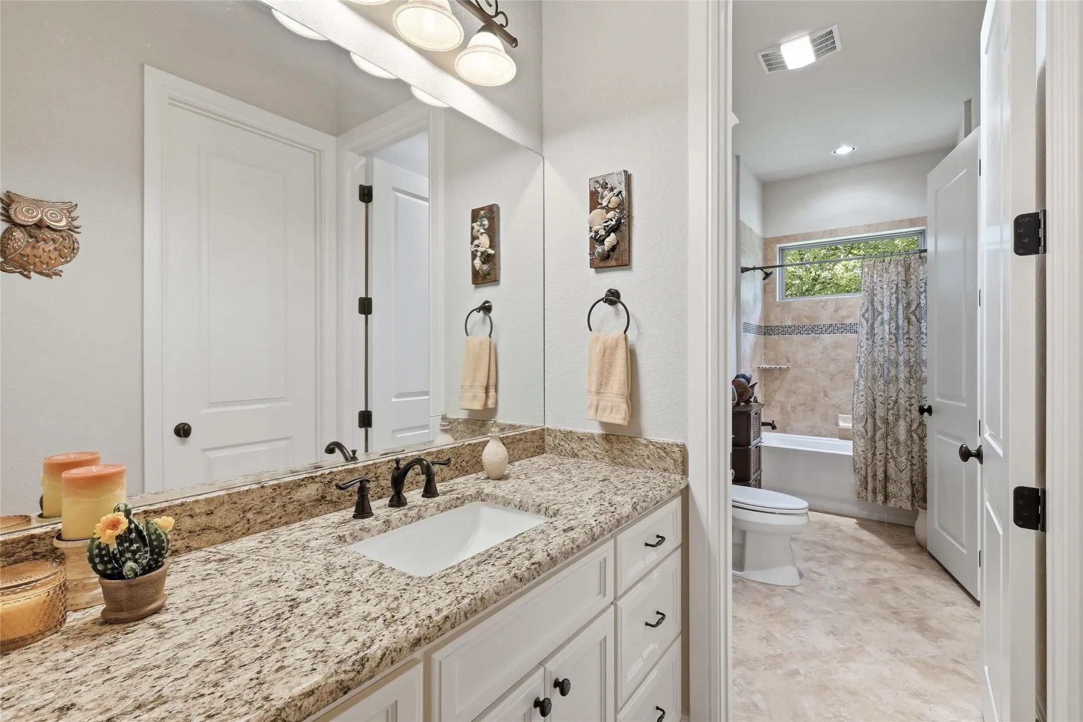 This bathroom has a sink and closet and around the corner you will find another vanity with it's own space