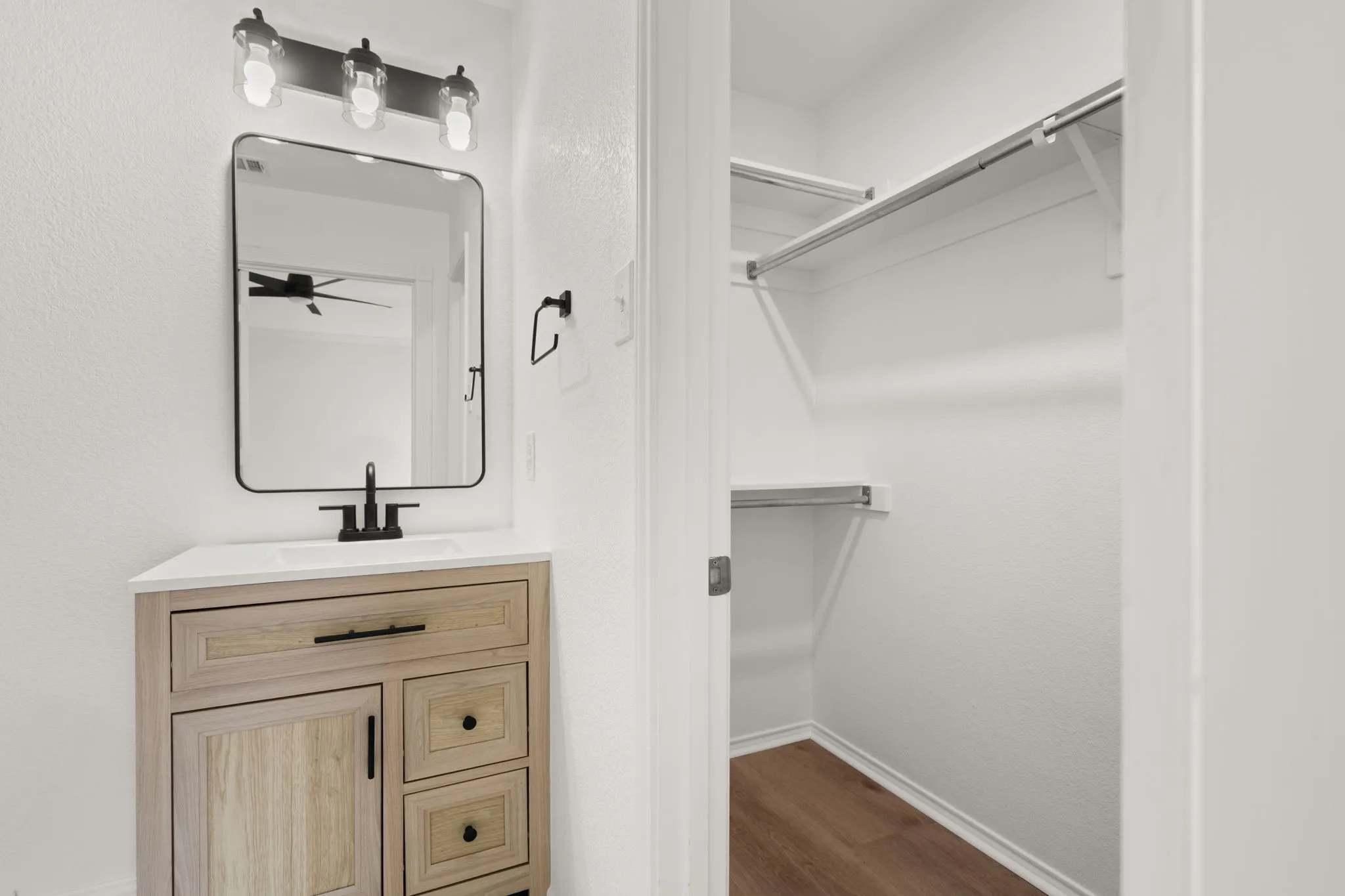 Modern vanity featuring wood-finish cabinetry, a white countertop, and a rectangular undermount sink