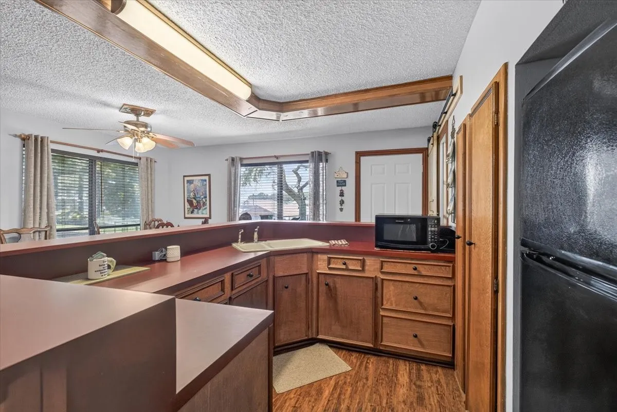 Guest quarters kitchenette features wrap around counters, cabinetry, double sink, microwave and refrigerator.