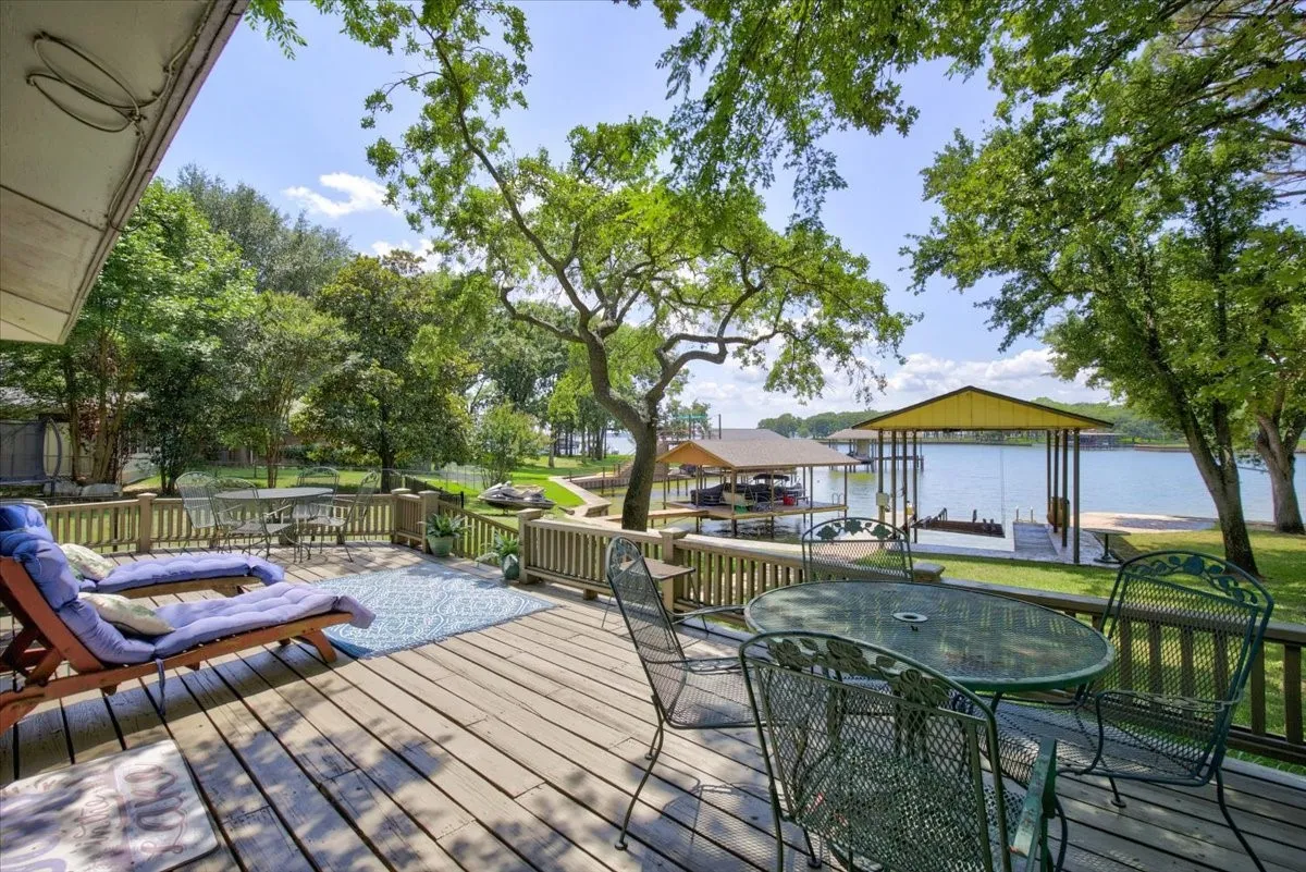 Expansive lakeside outdoor wood deck with rails. What a spacious place for all the family and friends.