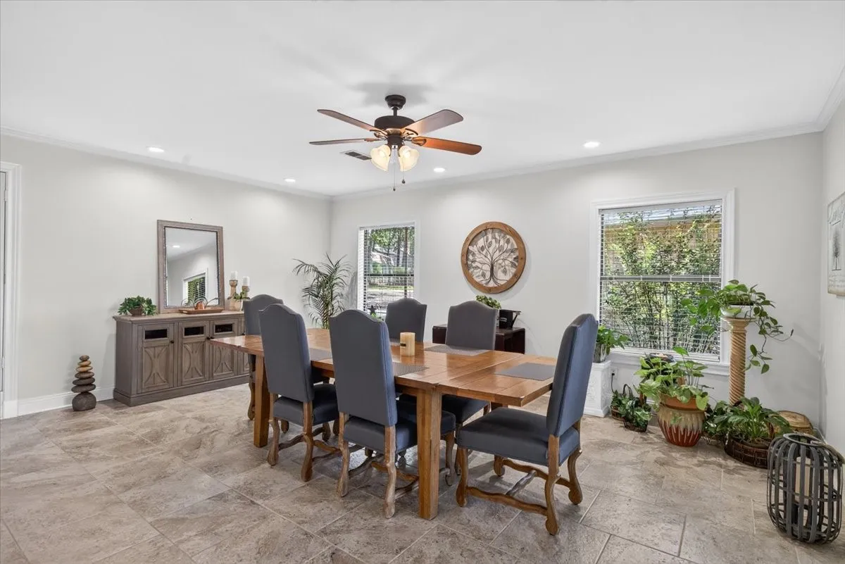 Spacious dining area featuring natural light, recessed lighting, ceiling fan and tile floor.