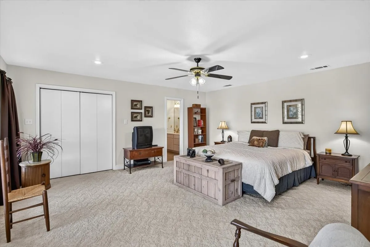 22nd floor Primary Bedroom with bath and featuring multiple large windows and a glass paneled door opening to a lakeside balcony. Behind the doors is a closet.