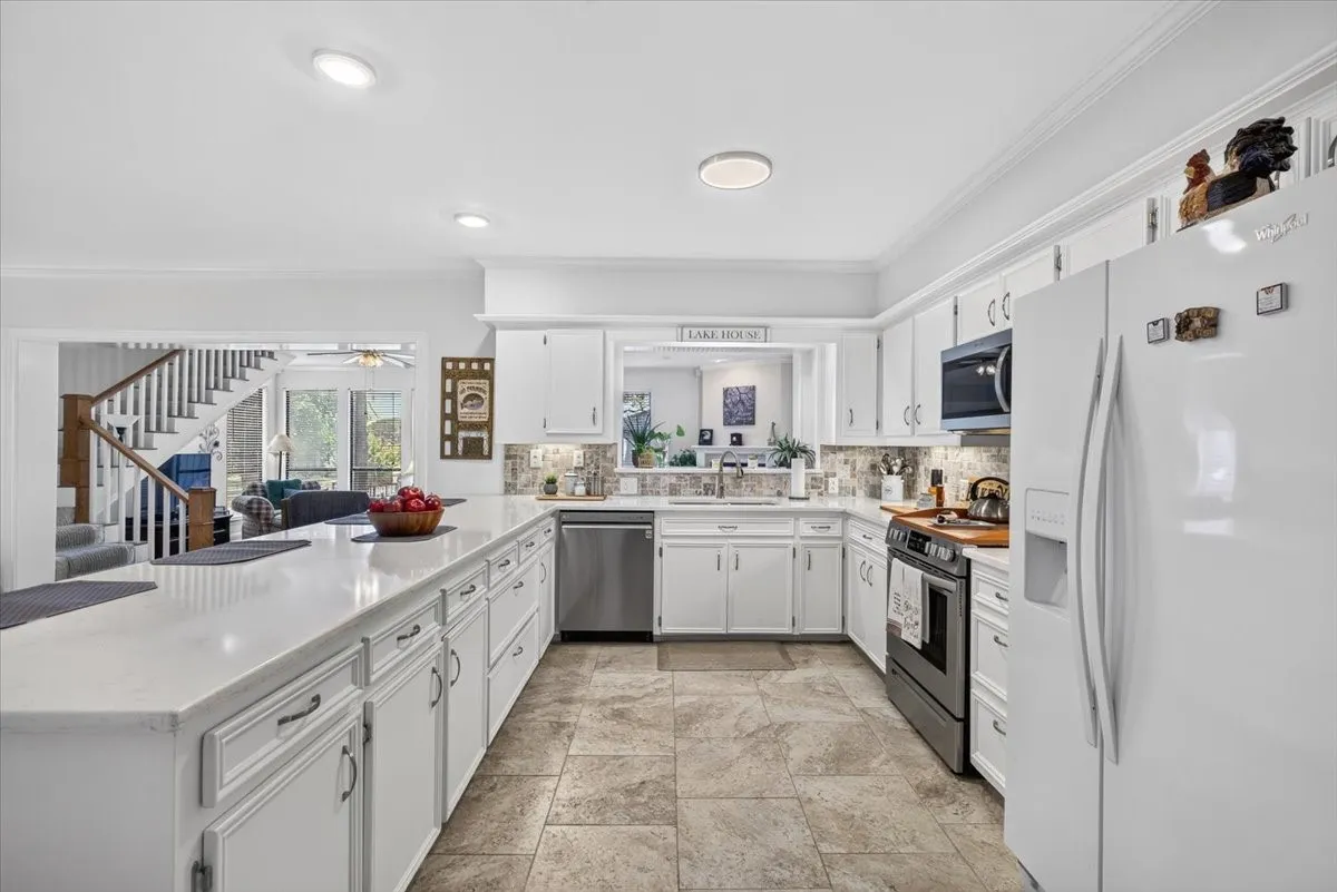 Kitchen featuring an expansive center island with beadboard paneling, quartz counters, and integrated breakfast bar with unlimited storage.