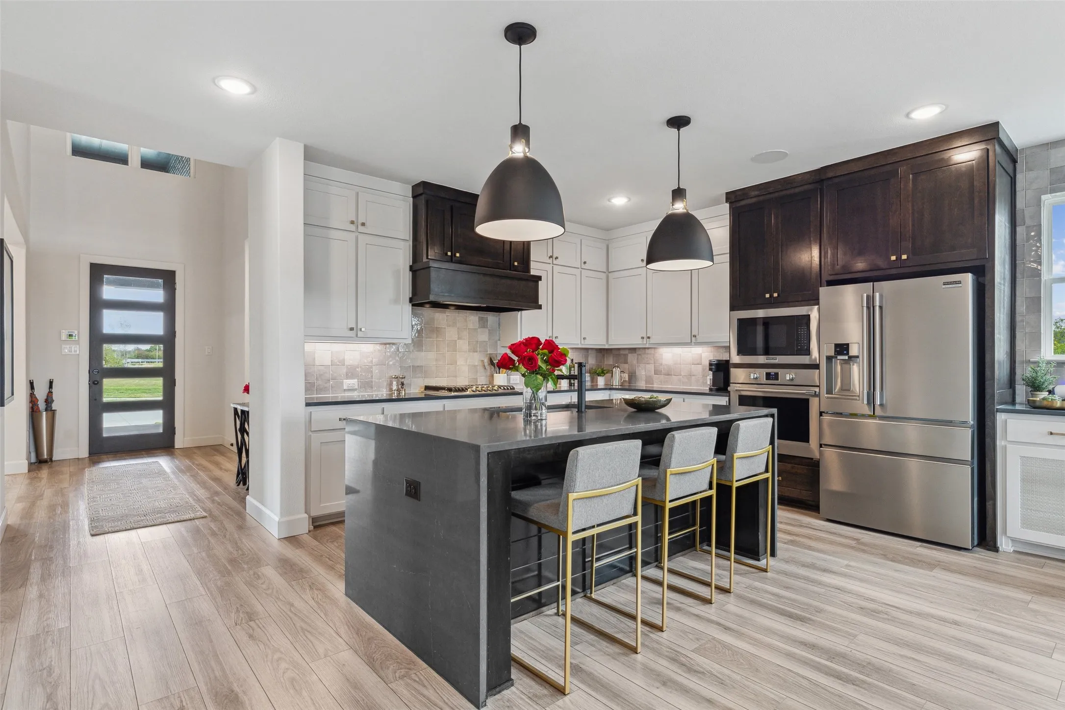 With dual stacked, two tone cabinetry and a waterfall island, this chef inspired kitchen is a dream come true!