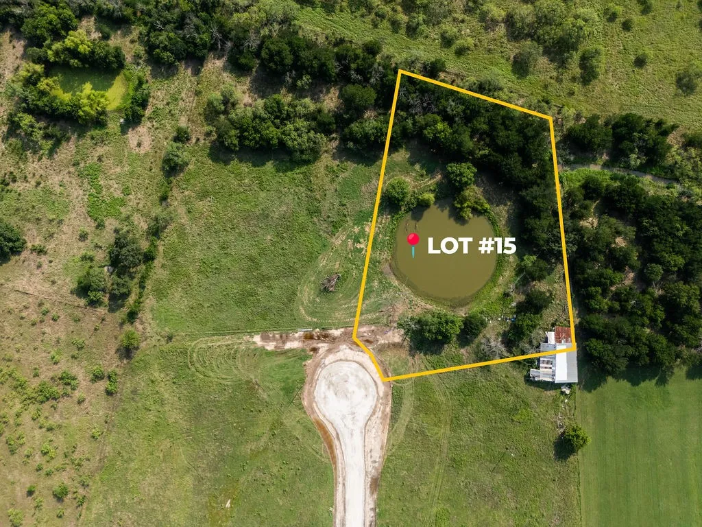 Expansive rural lot featuring a natural pond, mature tree coverage, open grassy areas, and a visible cul-de-sac entry