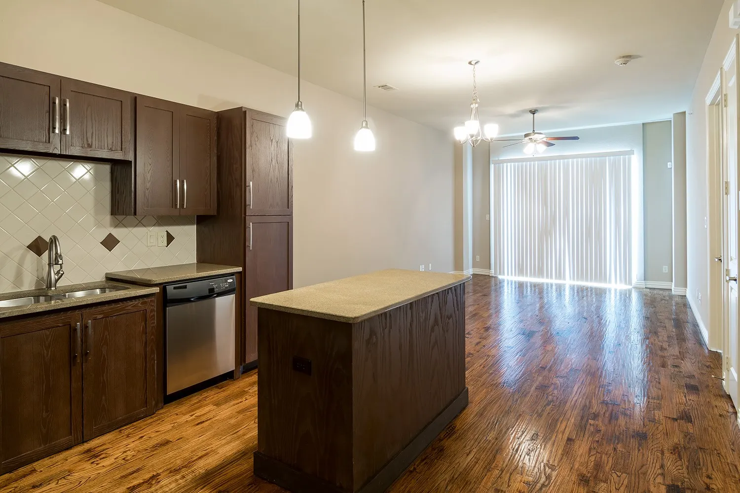 Kitchen featuring dark wood finish cabinetry, dark wood-style flooring, a kitchen island, and decorative backsplash