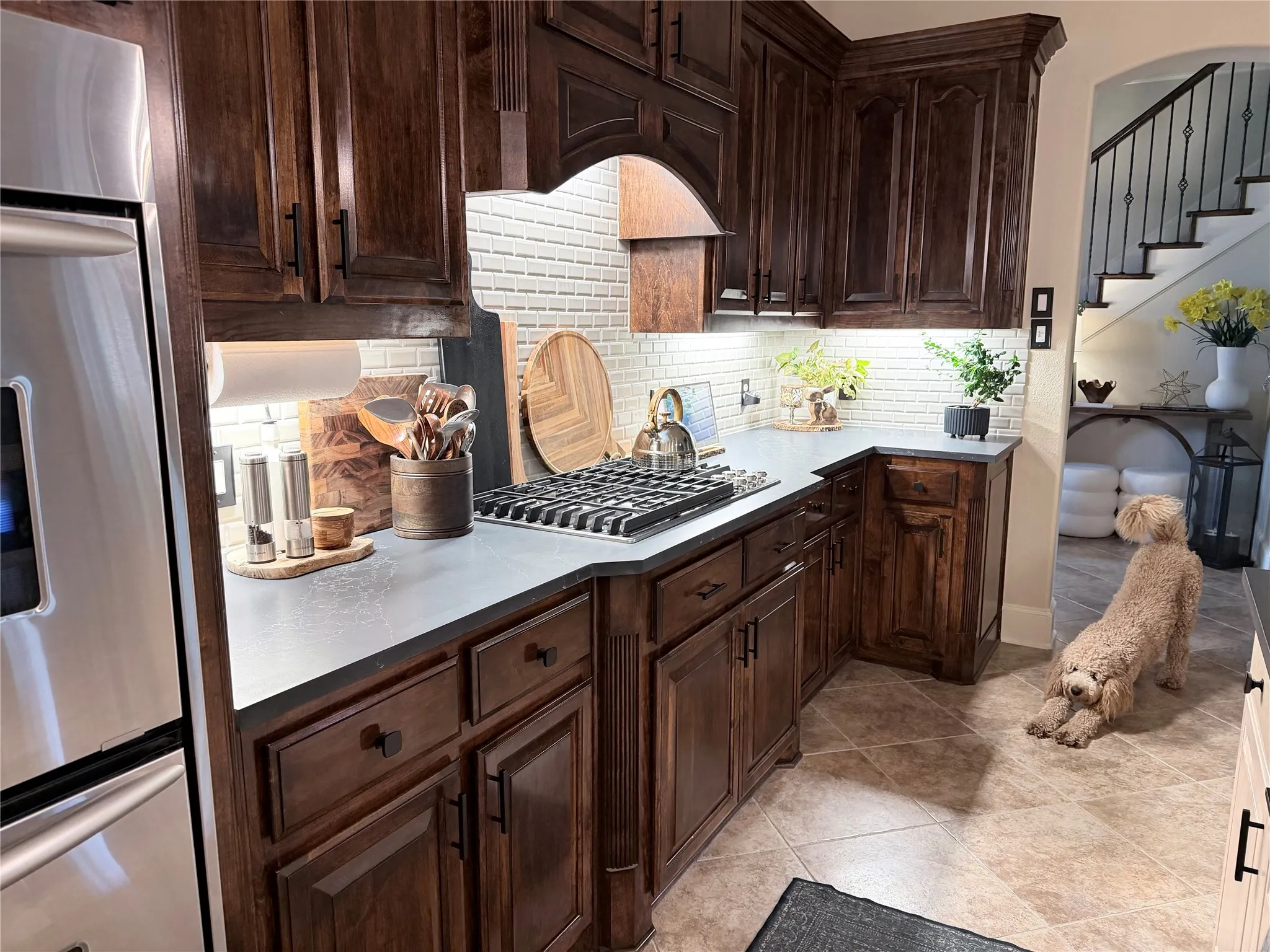 Stained hardwood cabinets, updated backsplash and quartzite countertops, puppy not included