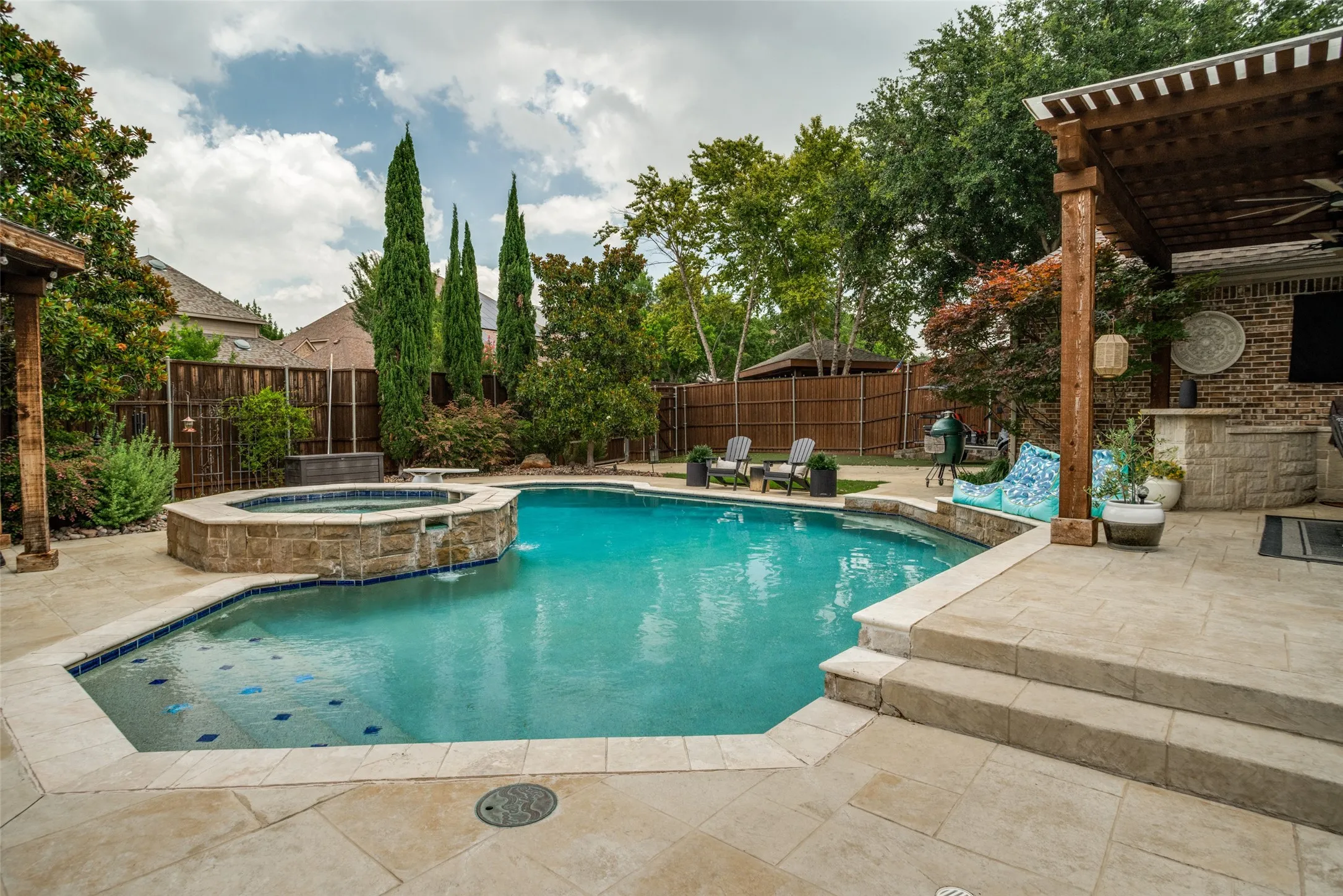 Private, gated back yard with mosquito misting system, putting green, oversized 8-ft deep pool with diving board, spa, covered patio, built-in gas grill and sport court.
