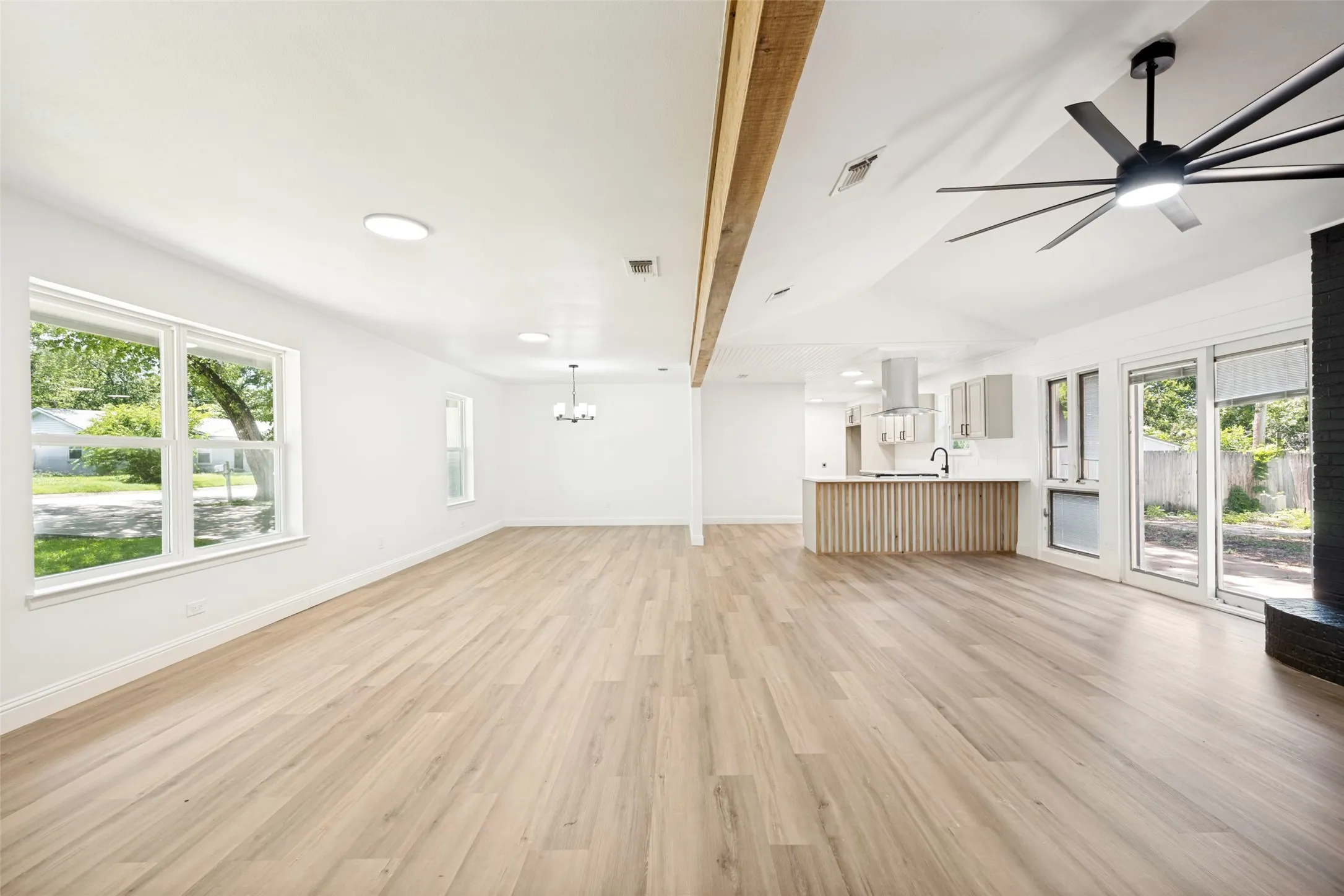 Open concept living space featuring wood-finish flooring, white walls, and recessed lighting