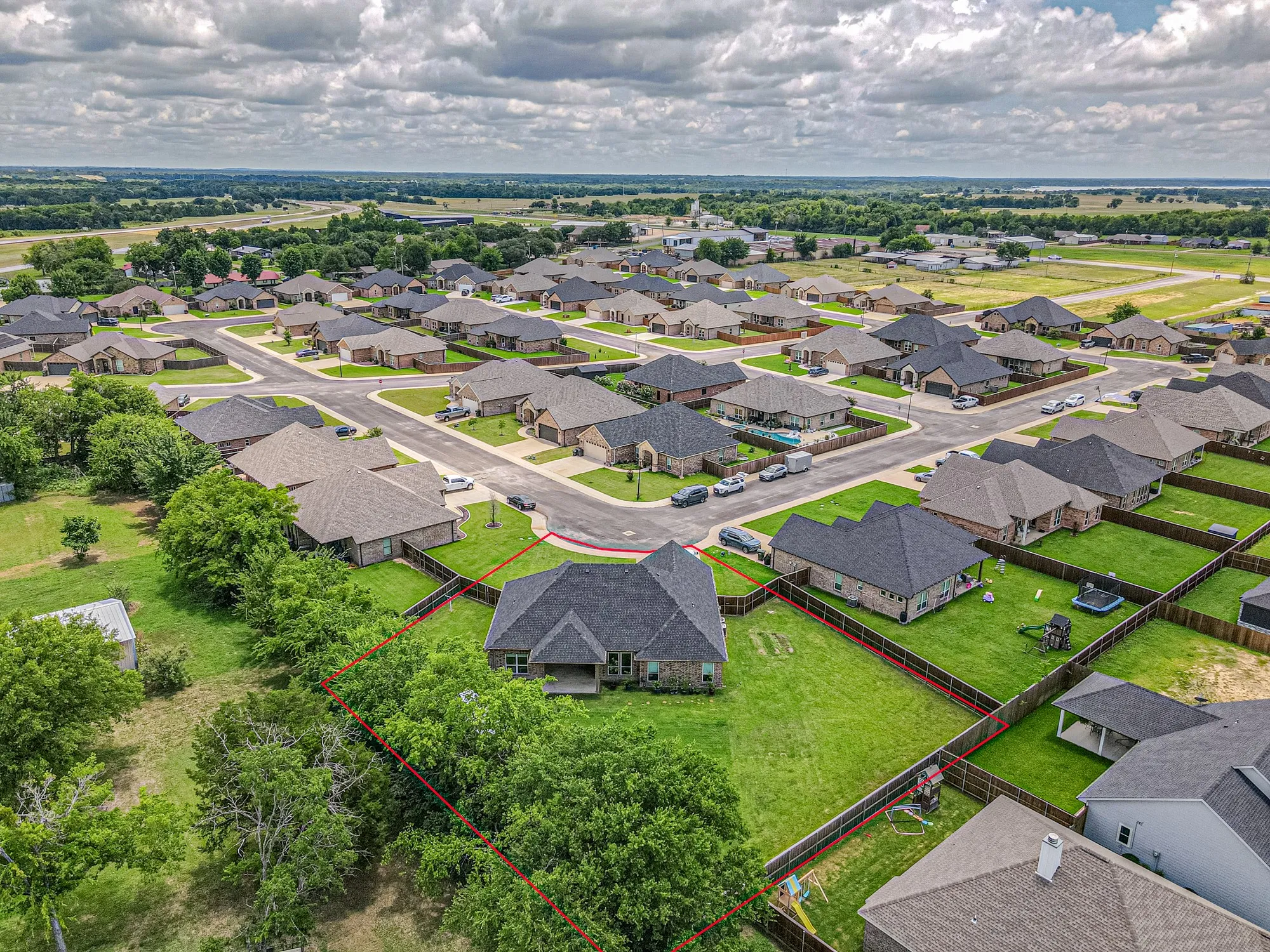Aerial perspective showcasing a residential neighborhood with a variety of single-story homes, each featuring dark shingle roofing