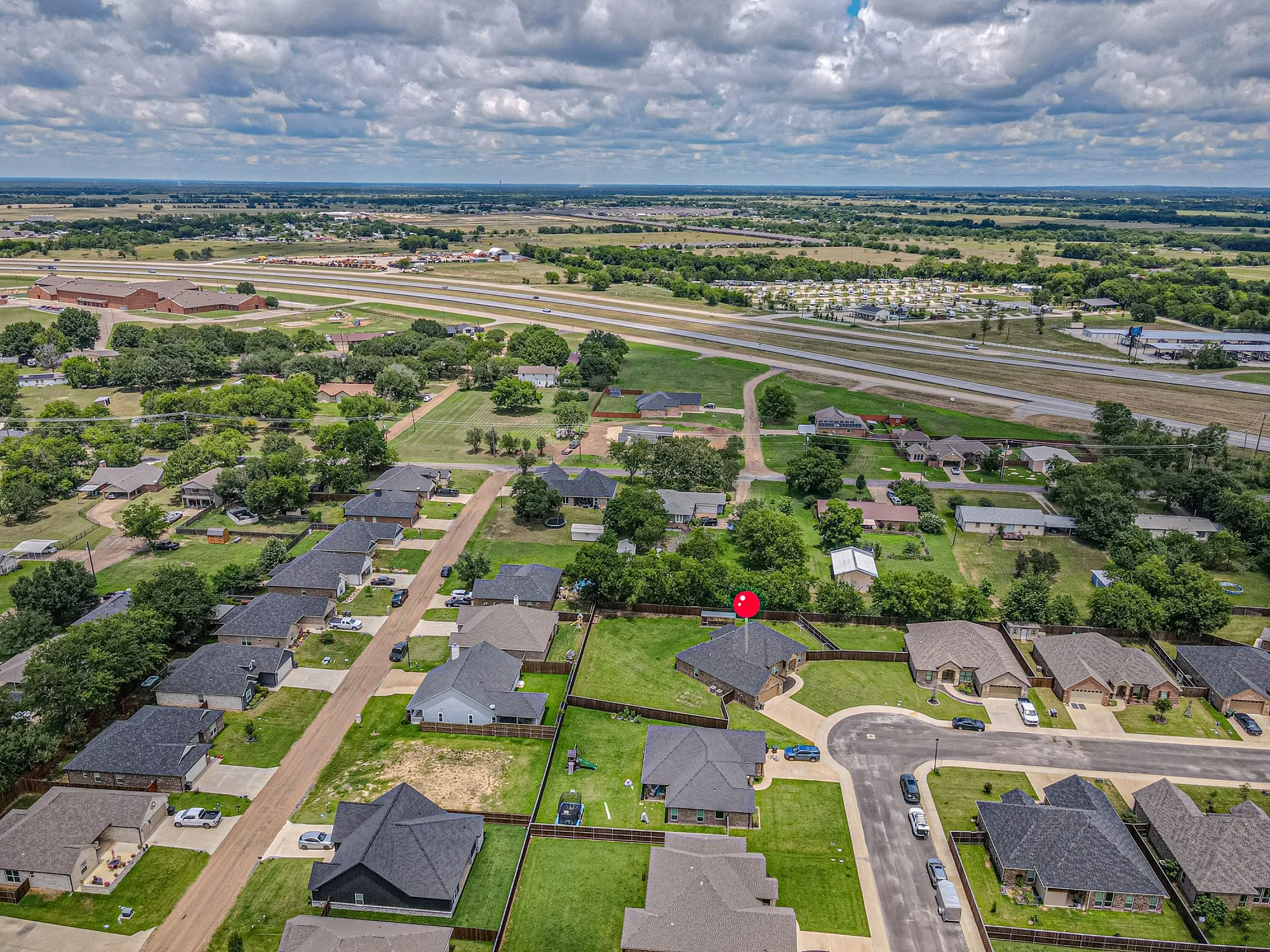 Aerial view of a residential neighborhood with single-family homes and established landscaping