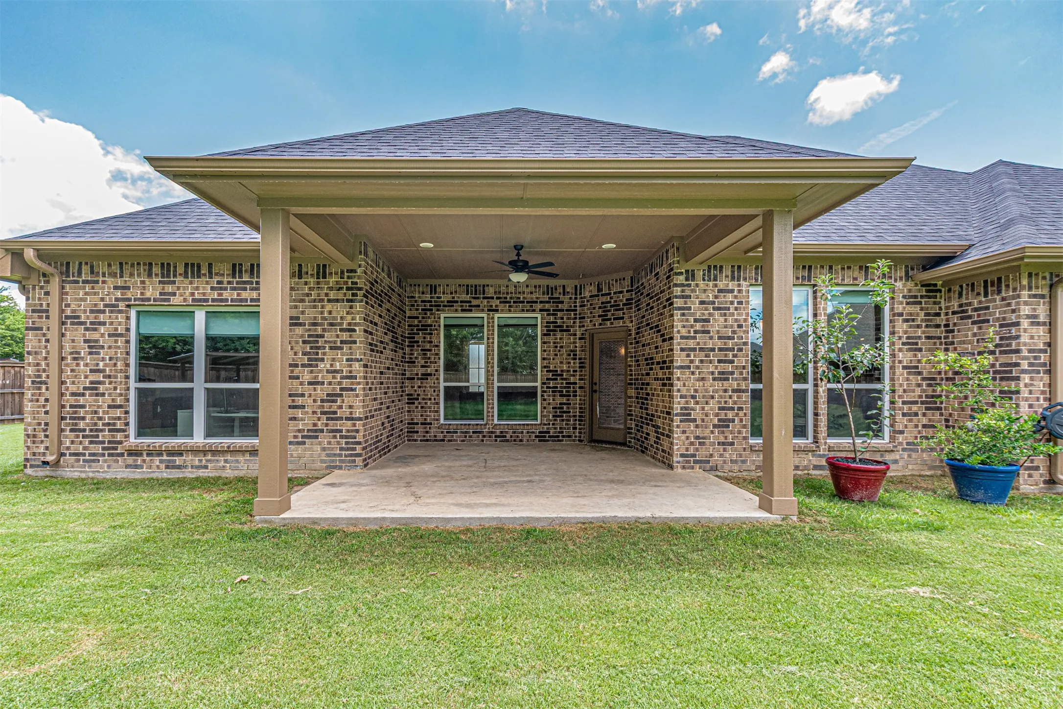 Covered patio featuring a ceiling fan, recessed lighting, and brick exterior walls