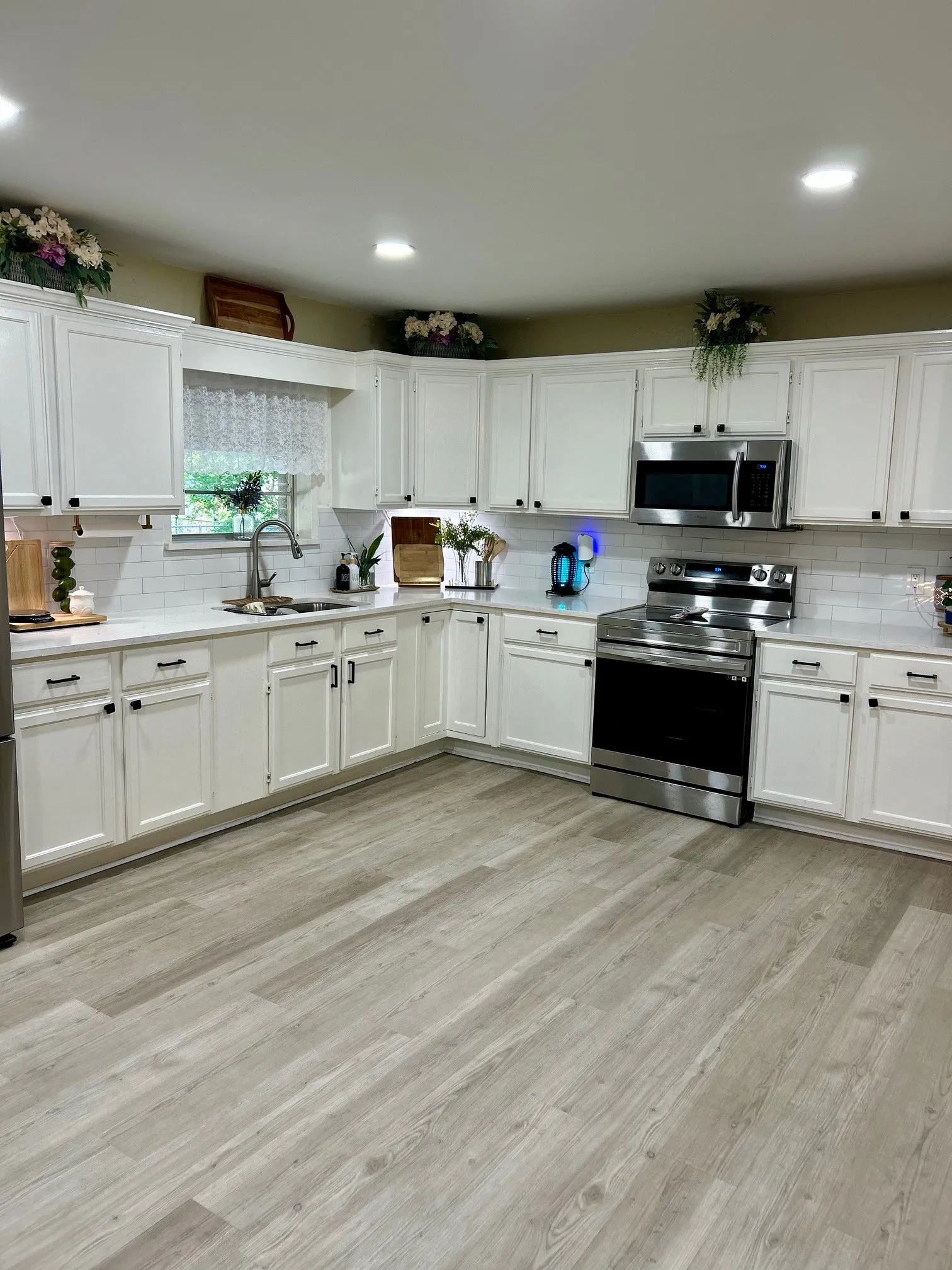 Kitchen with appliances with stainless steel finishes, backsplash, light wood-style flooring, light countertops, and recessed lighting