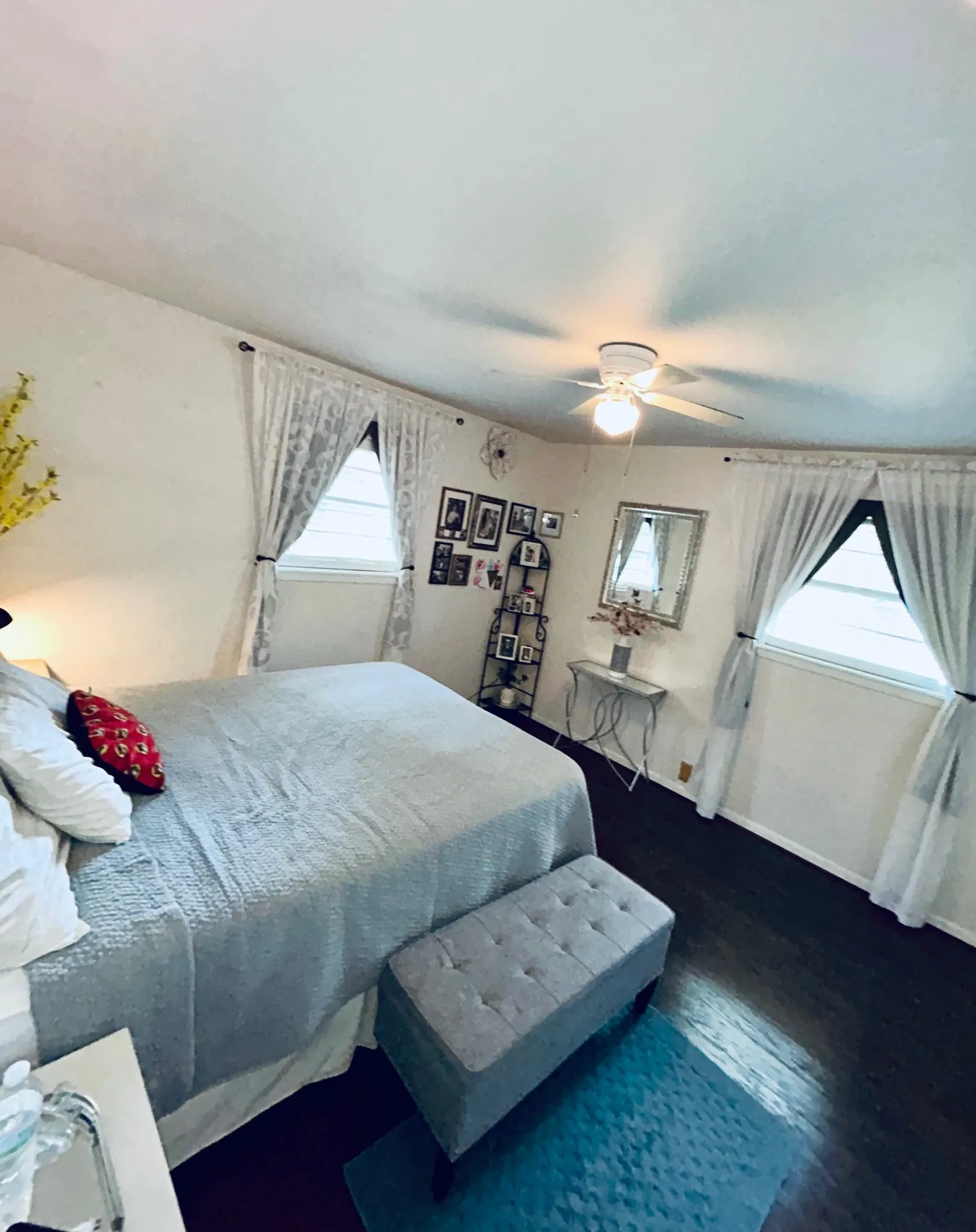 Bedroom featuring multiple windows, wood finished floors, and a ceiling fan