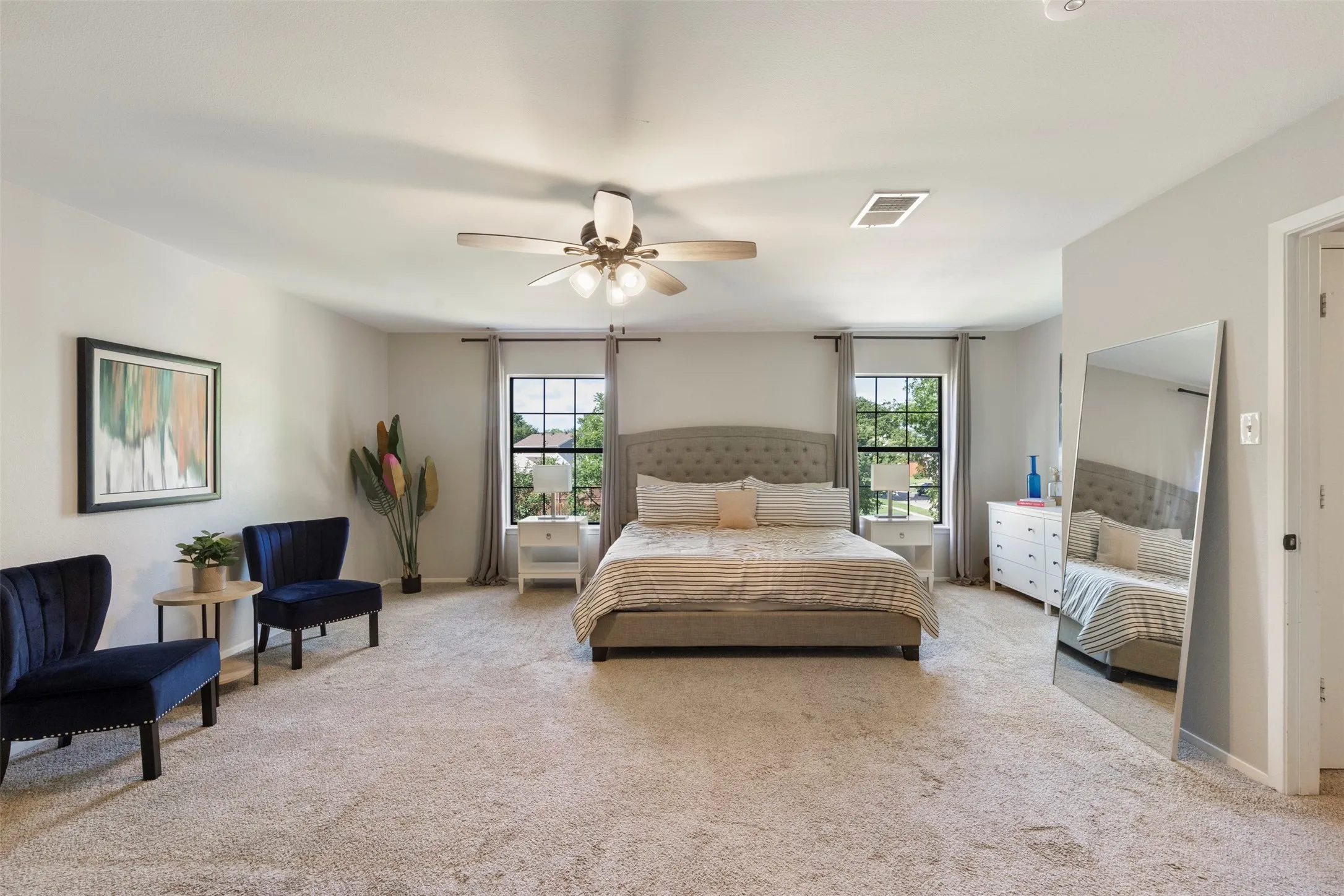 Spacious room featuring light gray wall paint, textured carpeting, and a ceiling fan with integrated​​‌​​​​‌​​‌‌​‌‌​​​‌‌​‌​‌​‌​​​‌​​ lighting