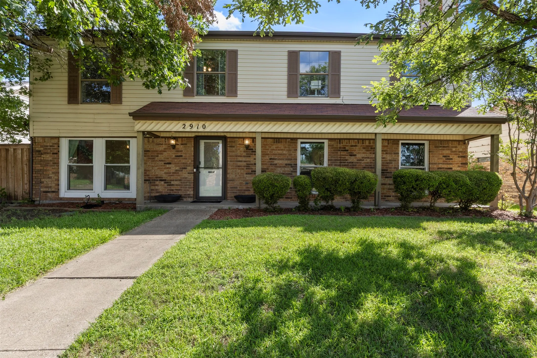 Two-story residential exterior featuring brick and siding construction