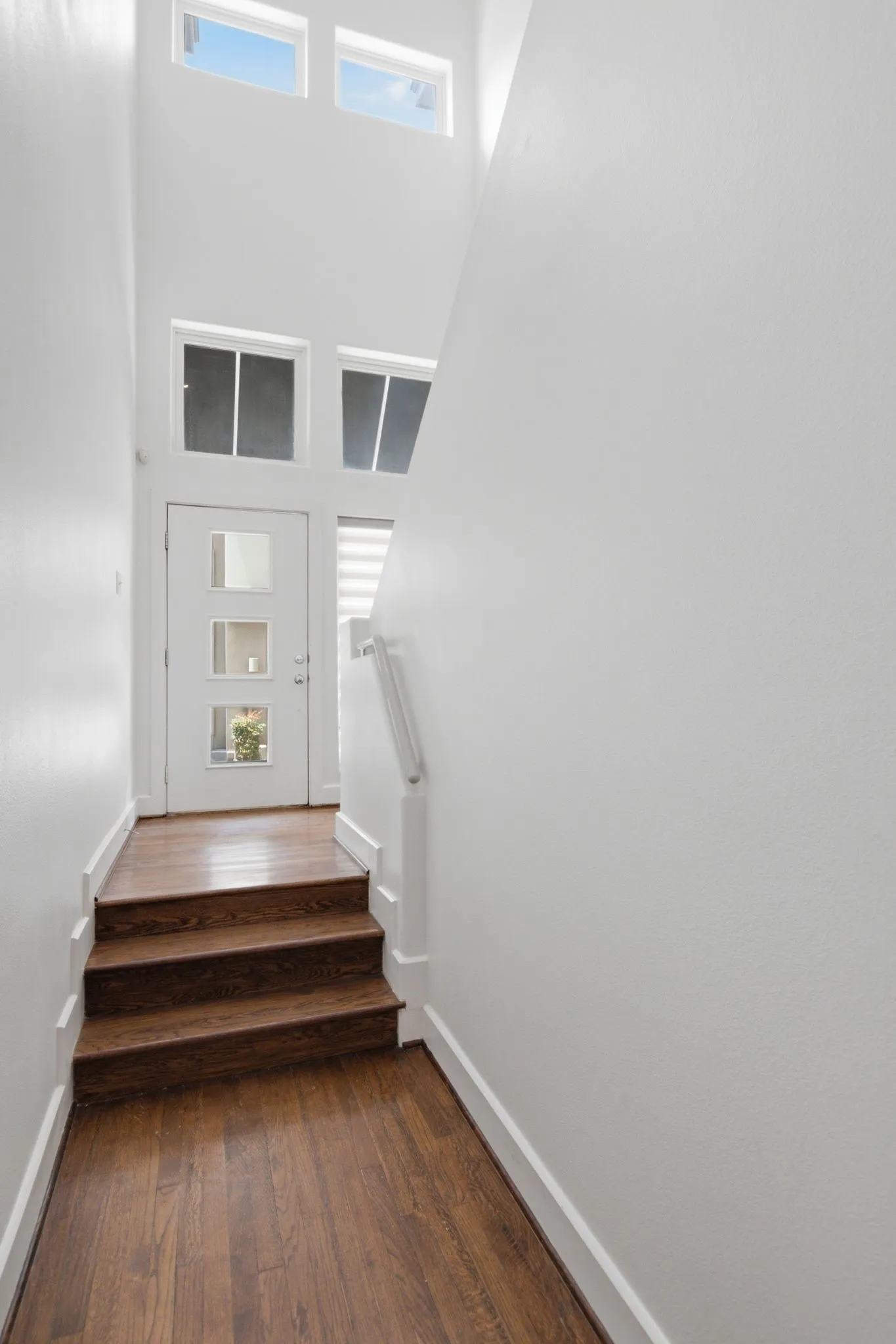 Entry foyer featuring wood-finish flooring and a three-step staircase