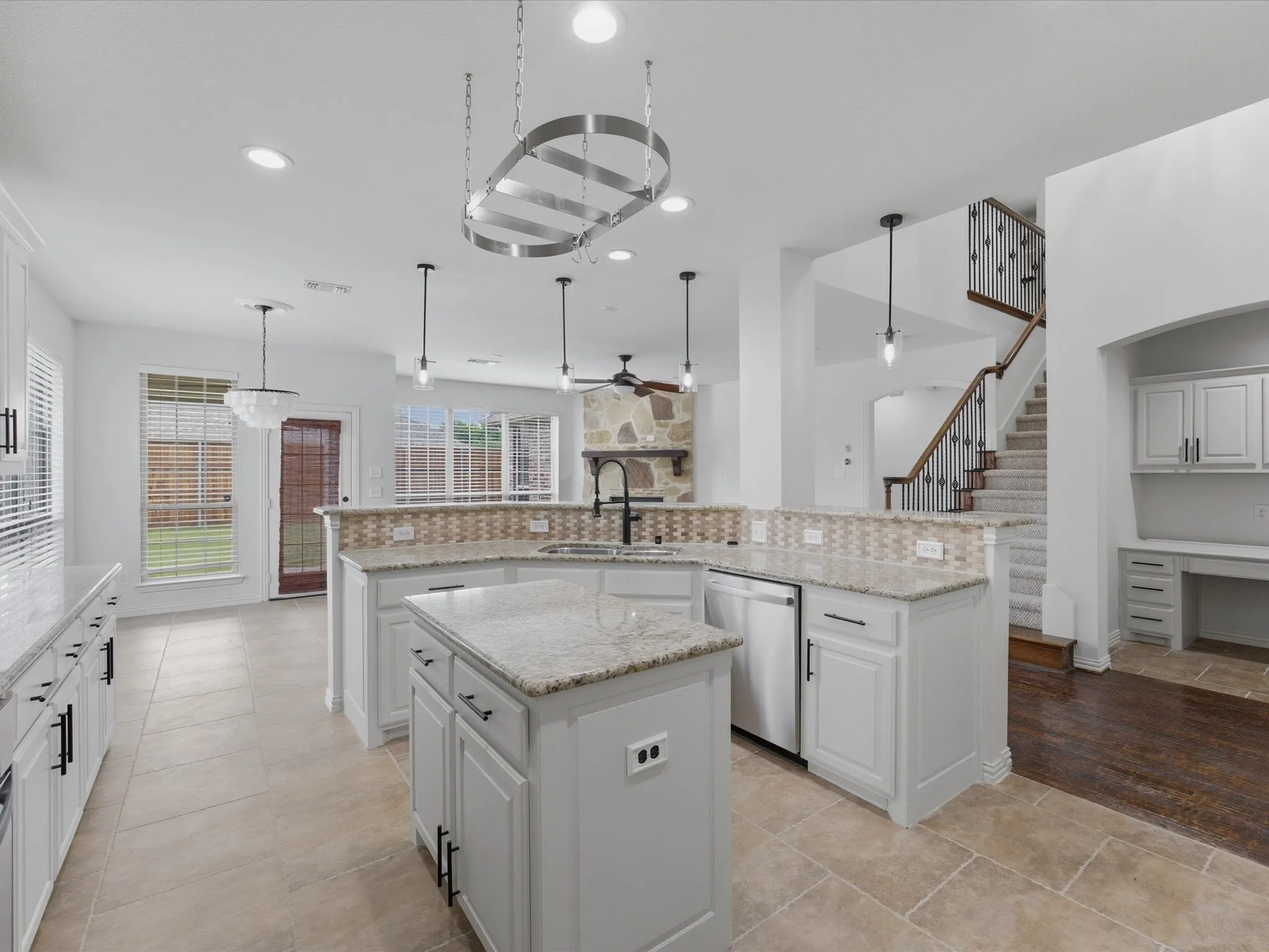 Open-concept kitchen featuring an island, light-toned cabinetry, granite countertops, stainless steel appliances, and tile flooring