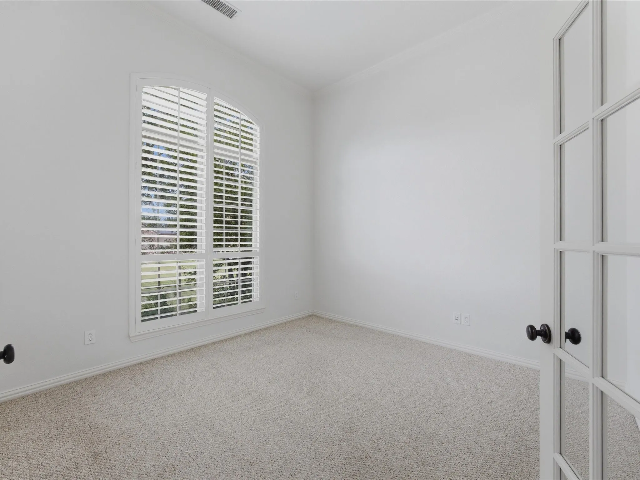 Arch-top window with plantation shutters