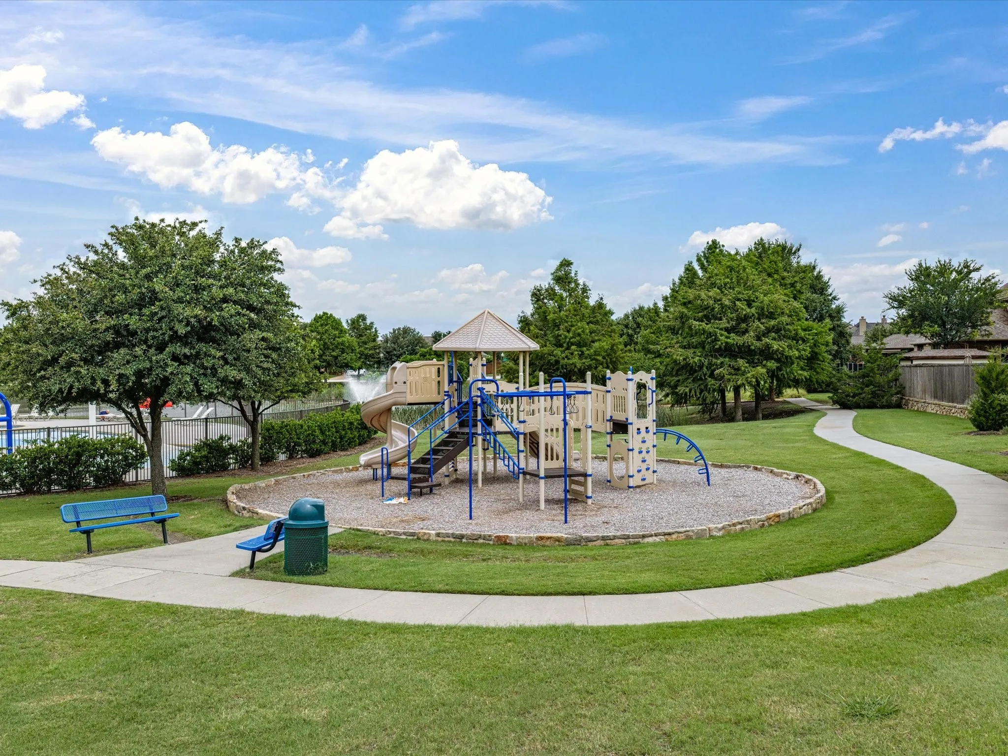 Community playground featuring multiple slides, climbing structures, and a shaded platform