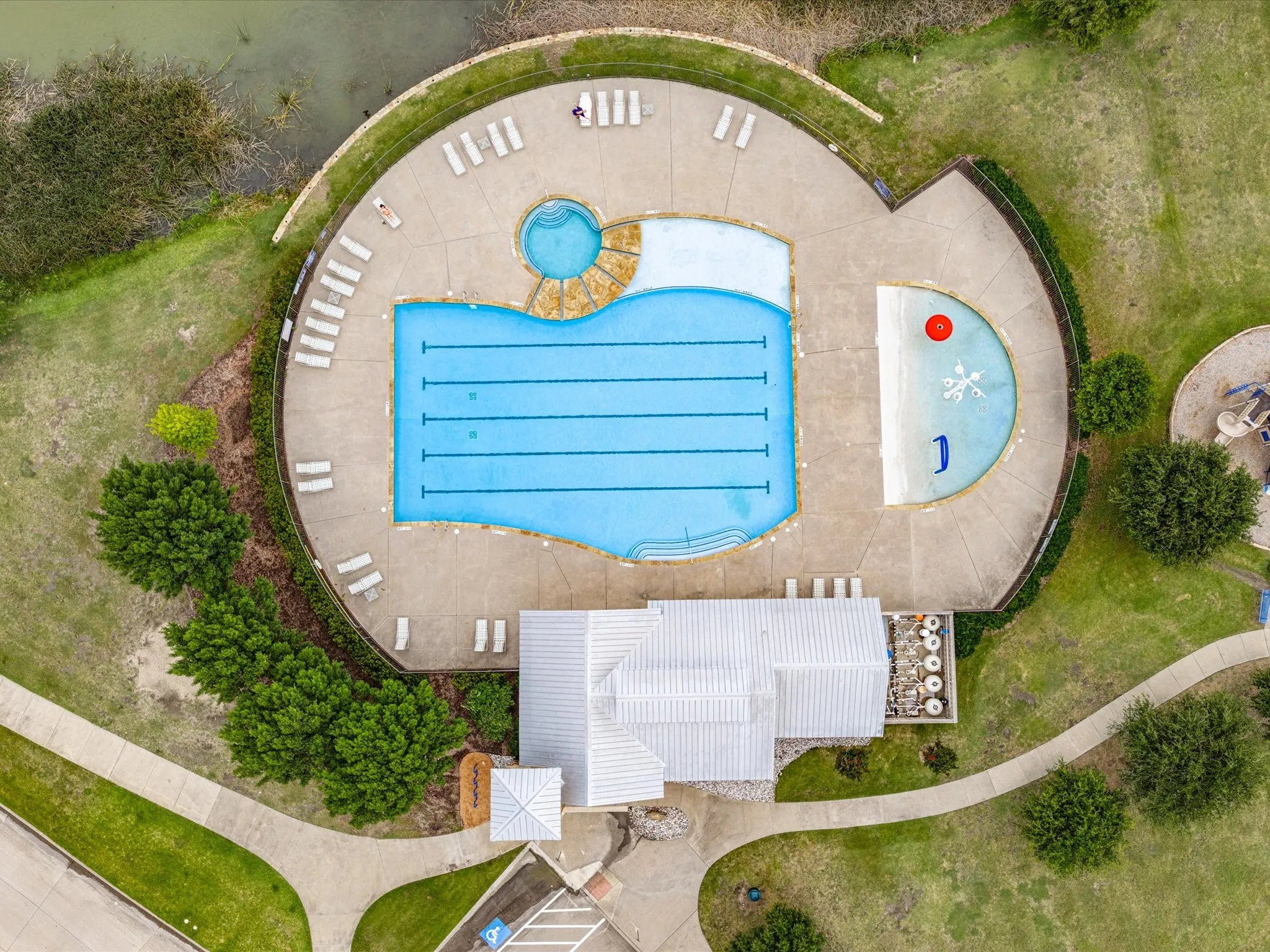 Community aquatic center featuring multiple swimming pools, a spa, and surrounding lounge areas