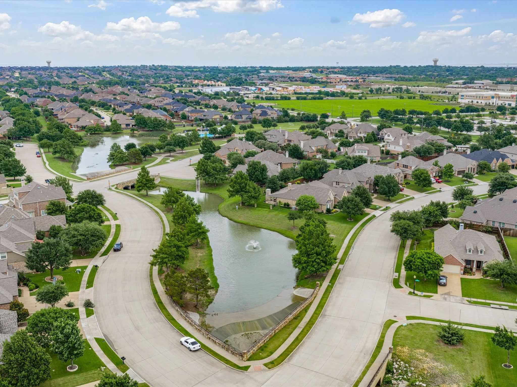 Residential community featuring a prominent central pond with a fountain