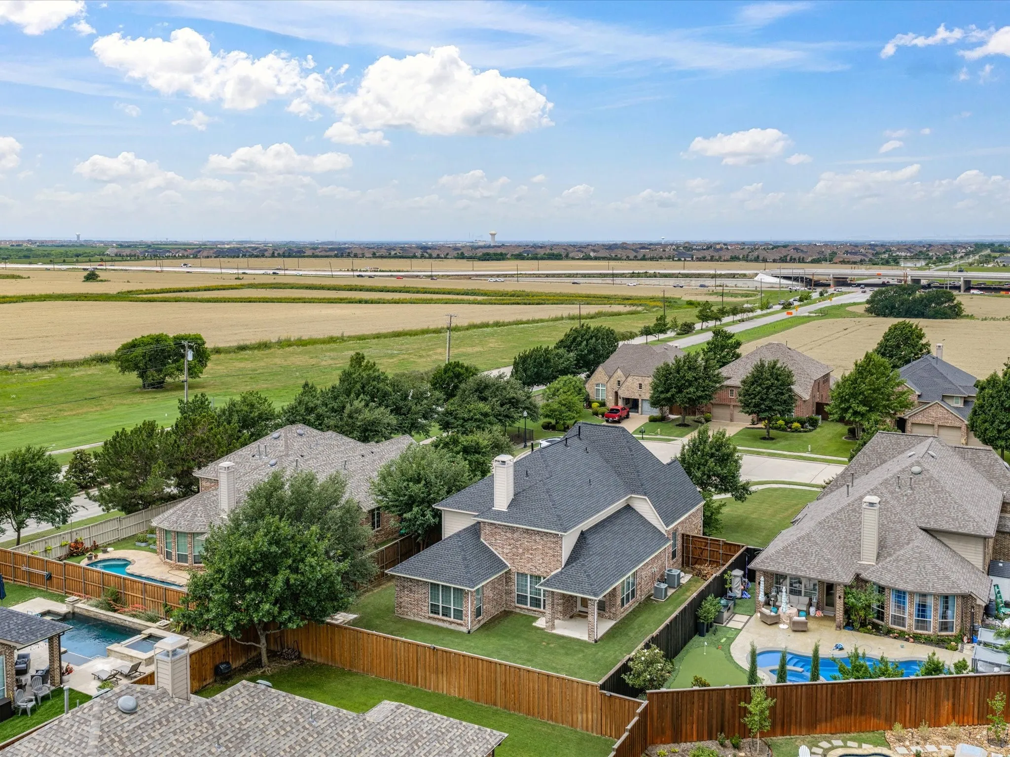Aerial perspective featuring a residential neighborhood with a prominent brick facade home