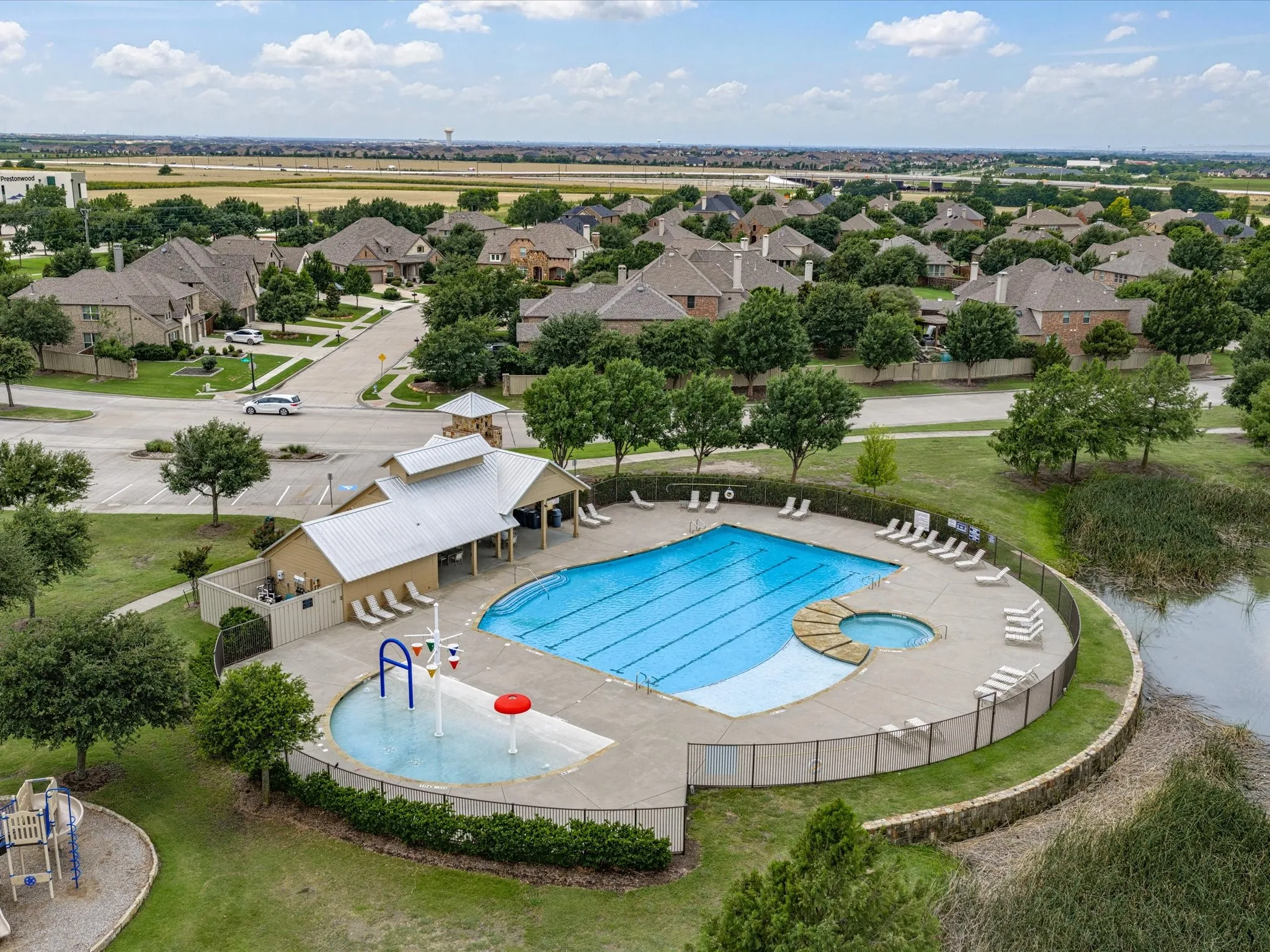 Community swimming pool featuring an integrated hot tub and expansive deck area with lounge seating