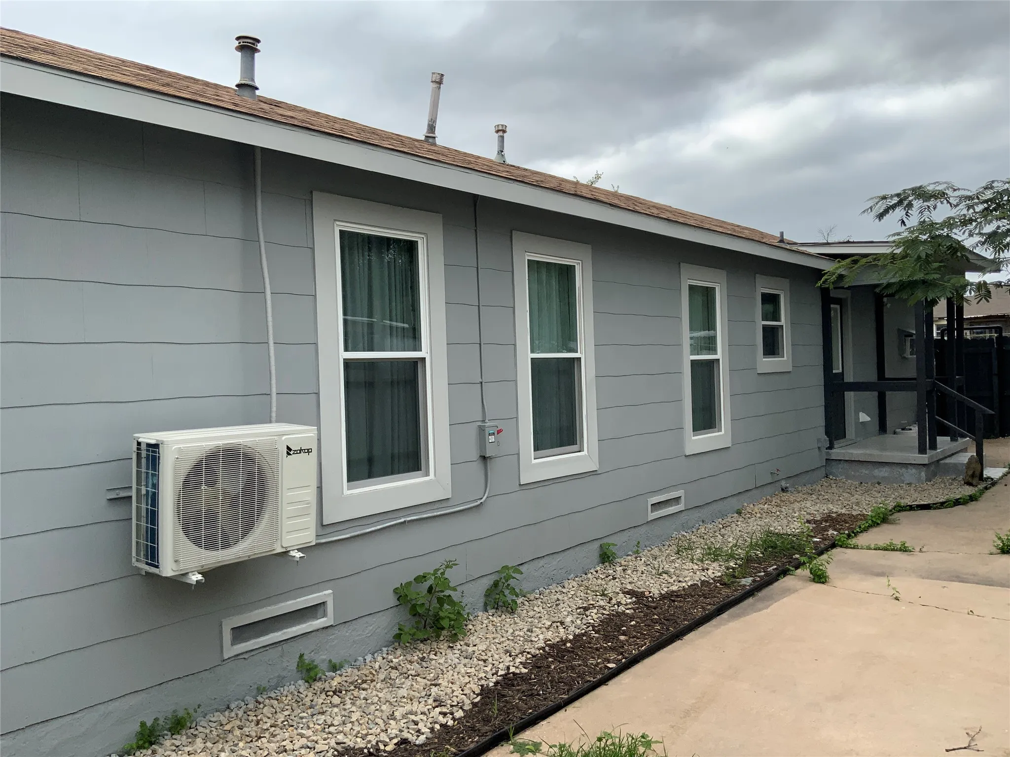 Light gray horizontal siding exterior with a brown shingle roof