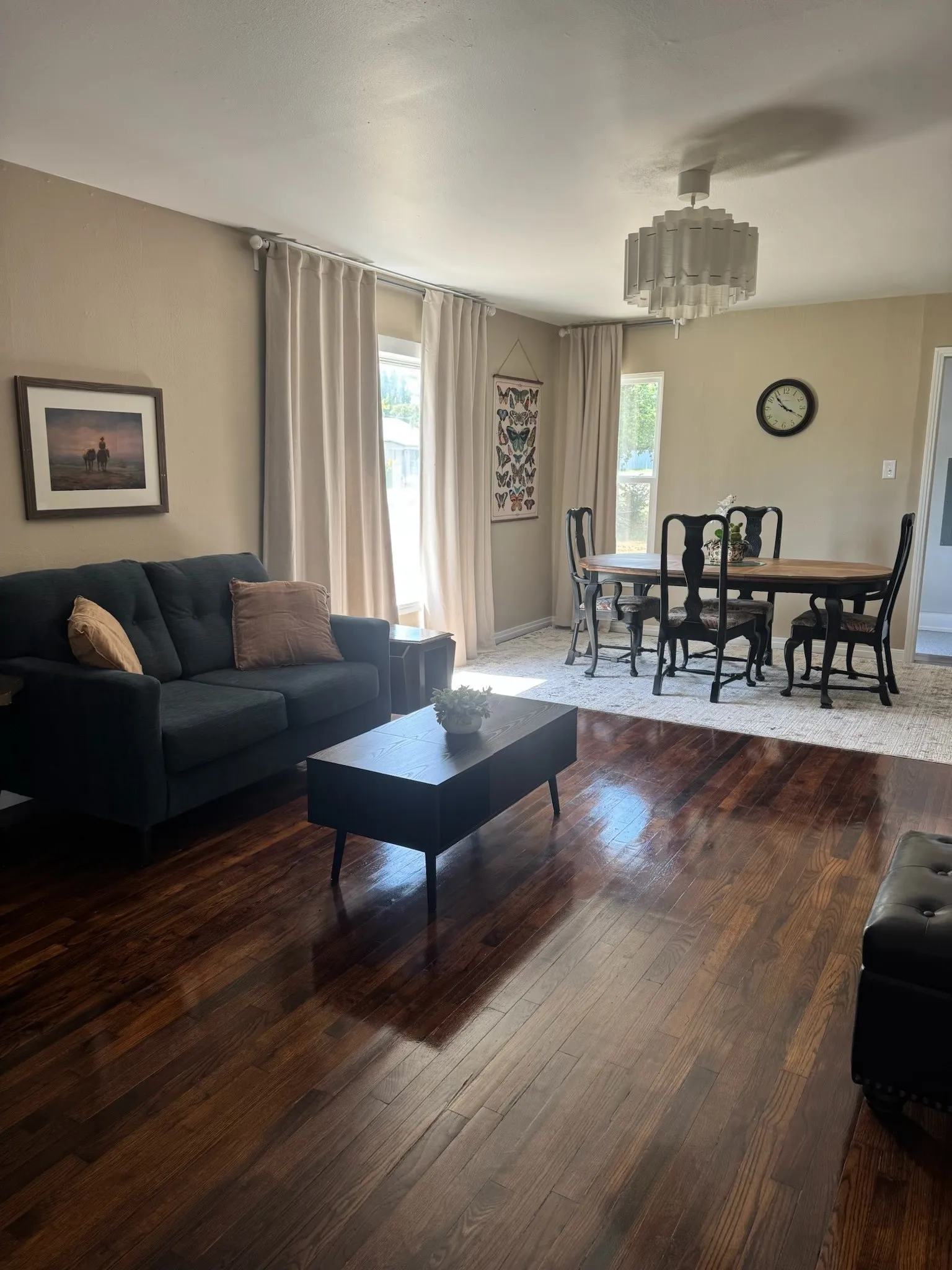 Open-concept living and dining area featuring dark wood-finish flooring