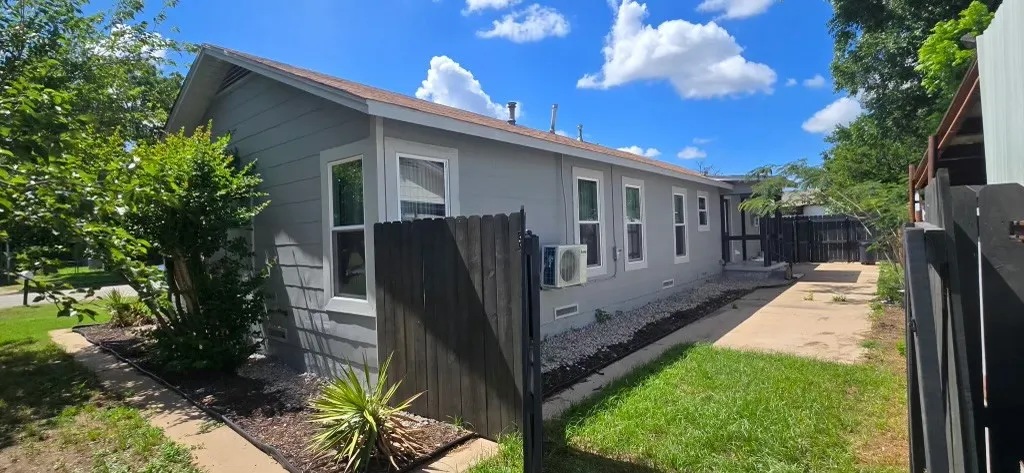 Single-story home featuring light gray siding with white trim around windows